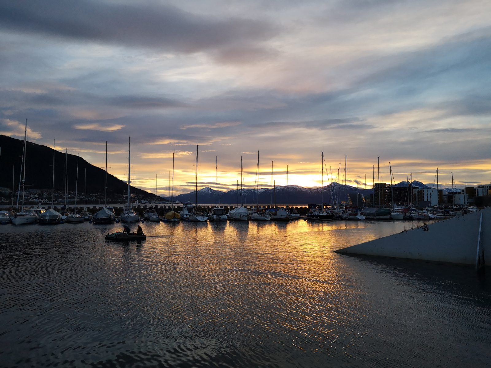 The sailing port in Tromso, with a sunset in the background.