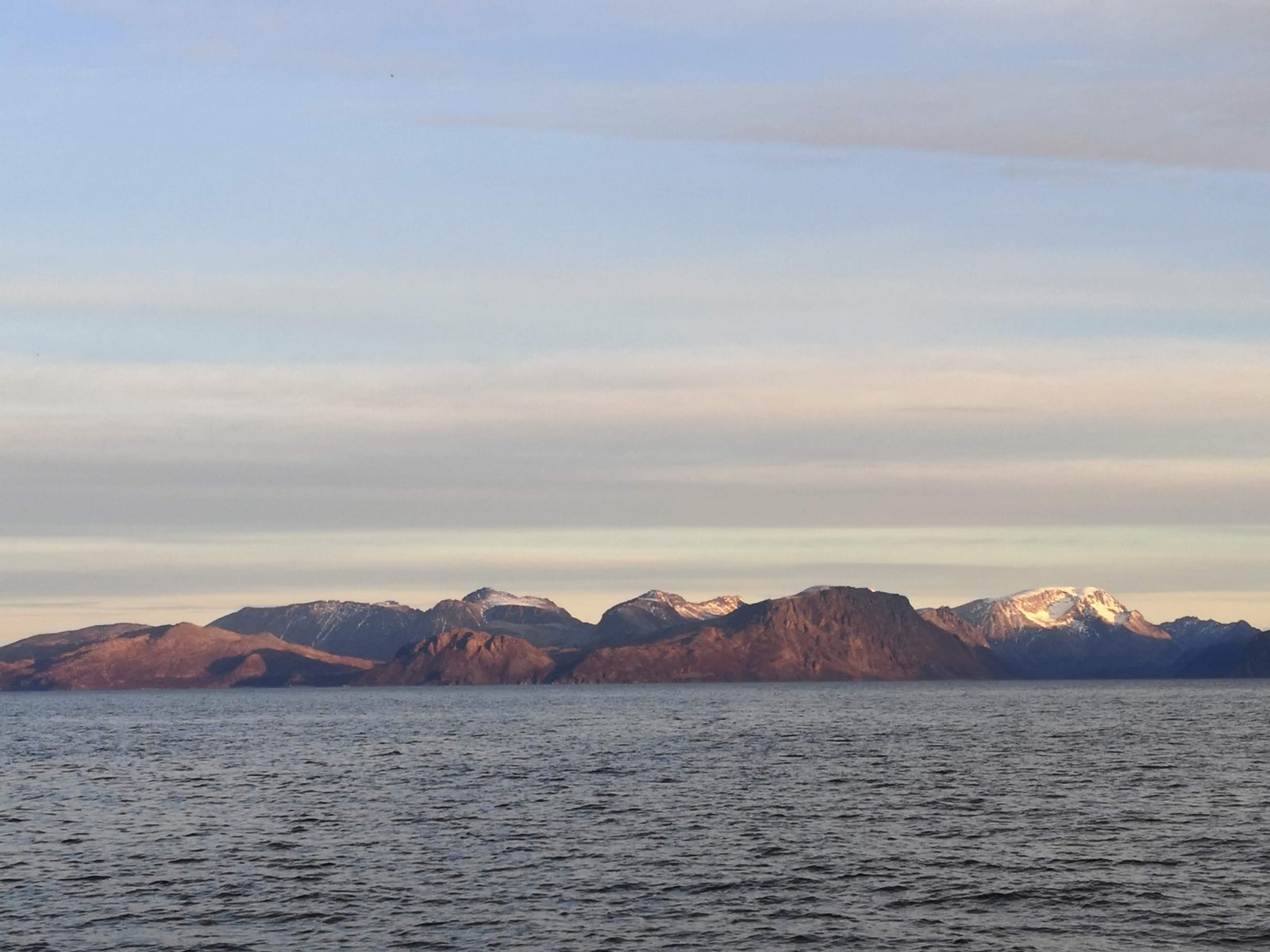 The layering shape of the Norwegian fjords on the horizon.