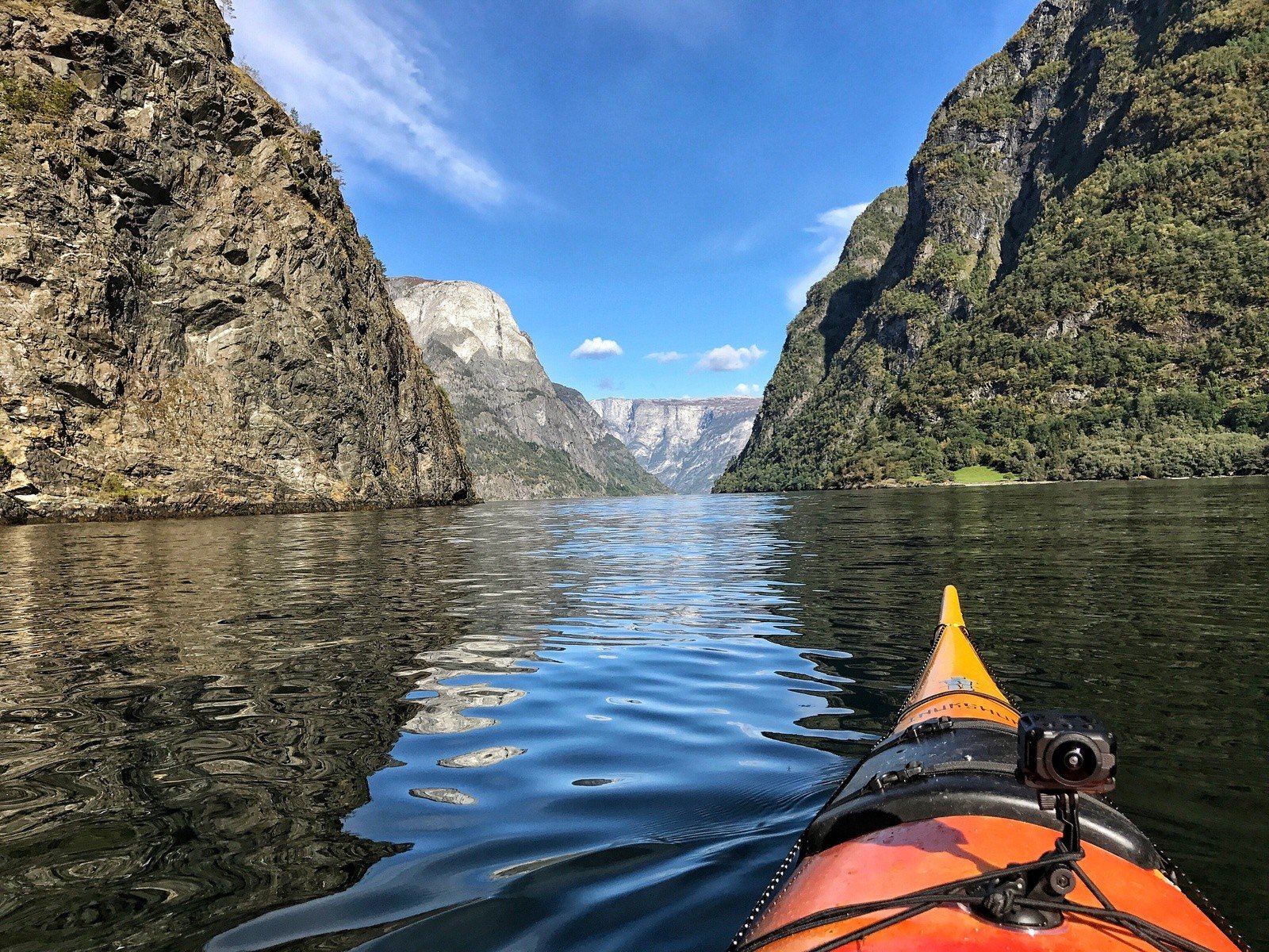 The front of a kayak gliding across the Norwegian fjords.