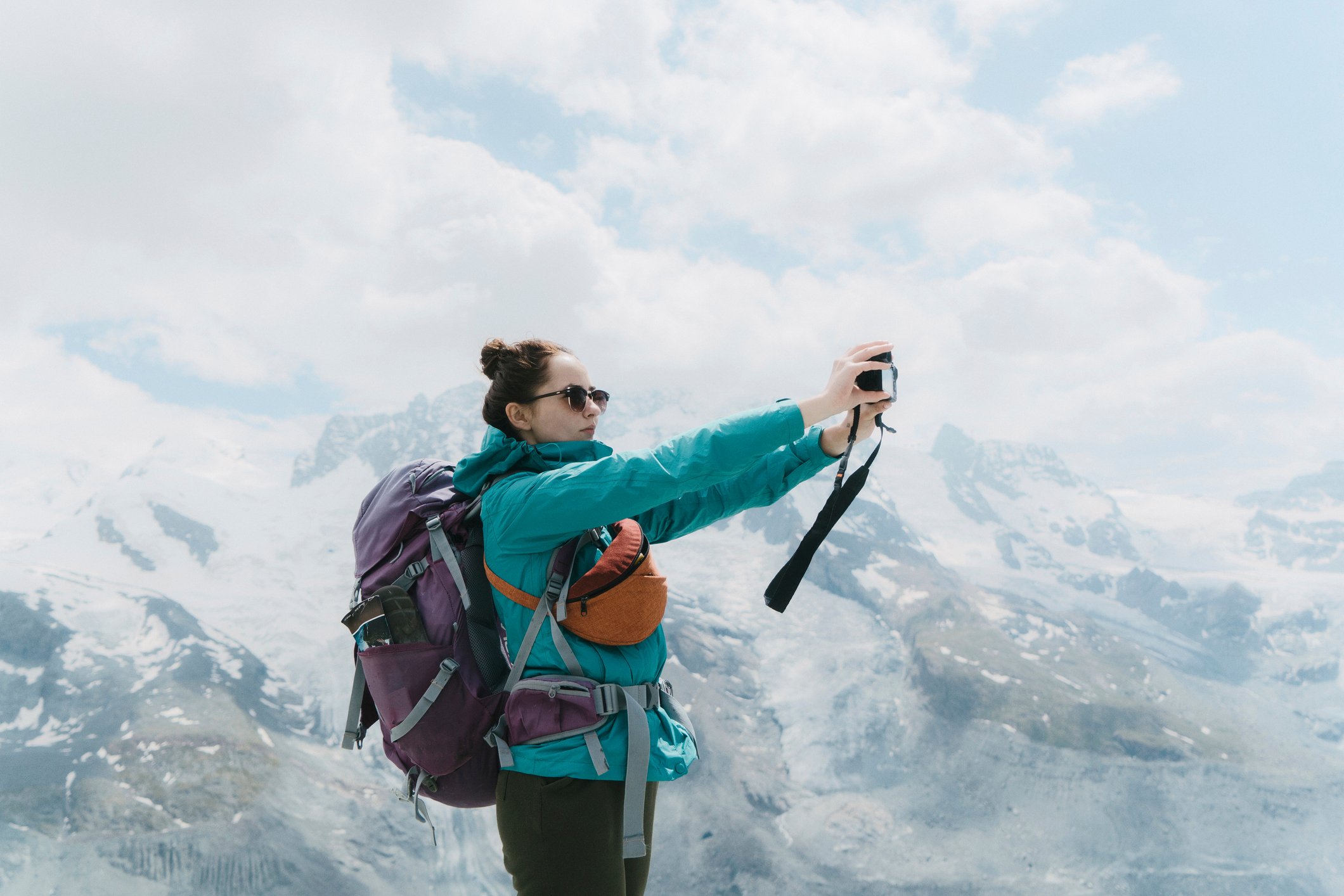 A female hiker taking a selfie in the mountains.