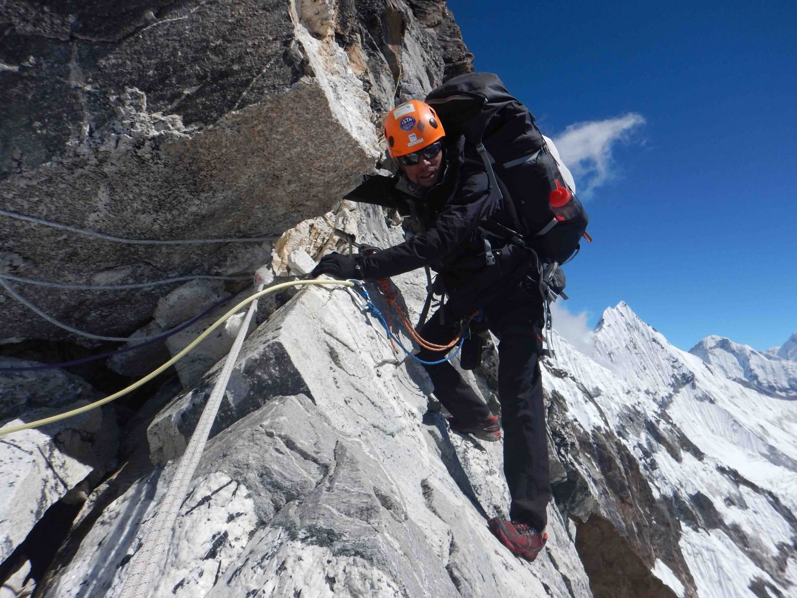 A mountaineer climbing on Mardi Peak, attached to ropes.