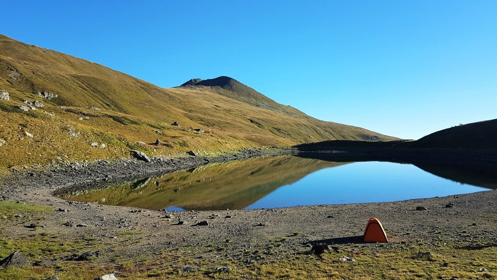 A tent near a small lake - an ideal wild camping spot.