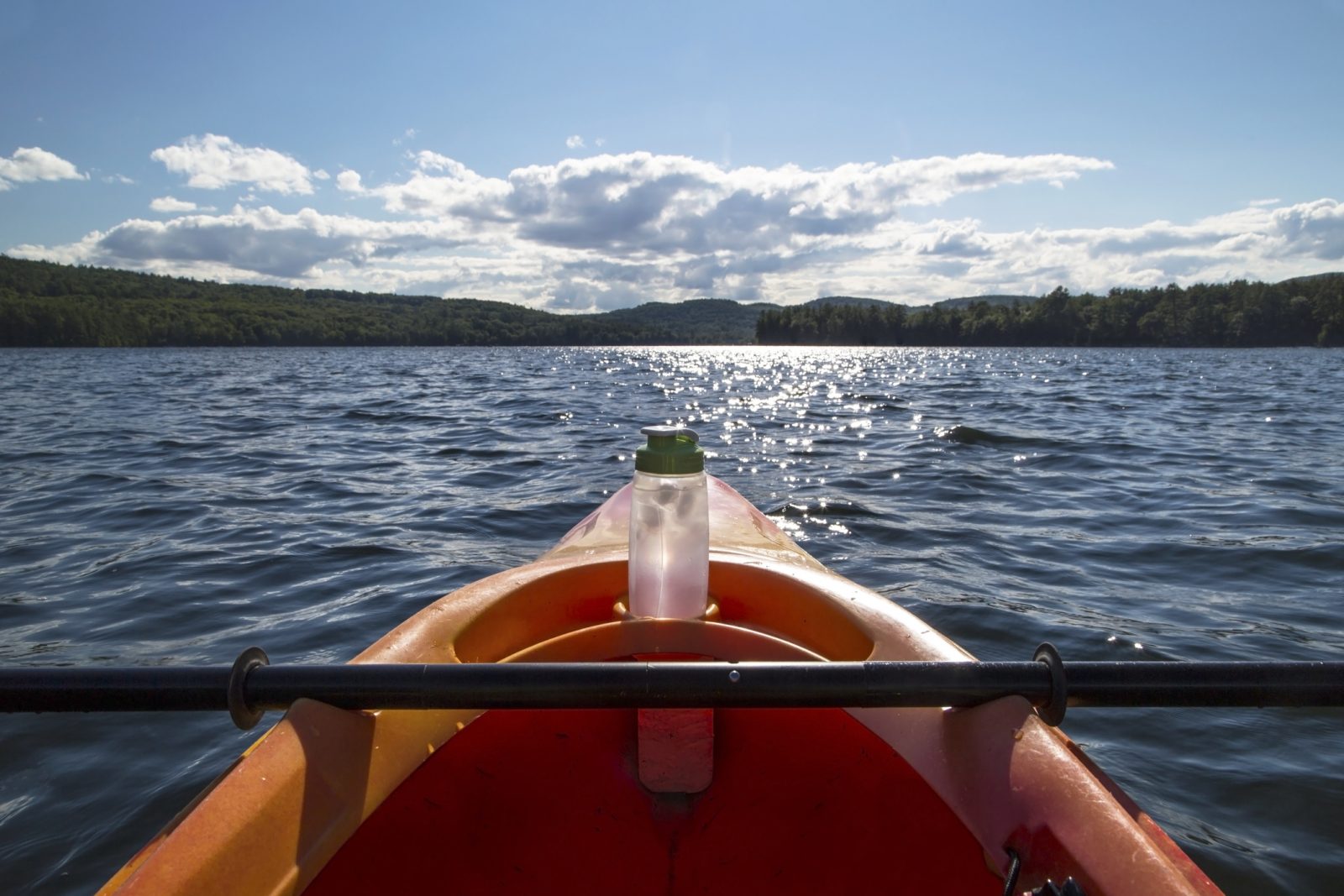 A kayak with a reusable water bottle at the front.