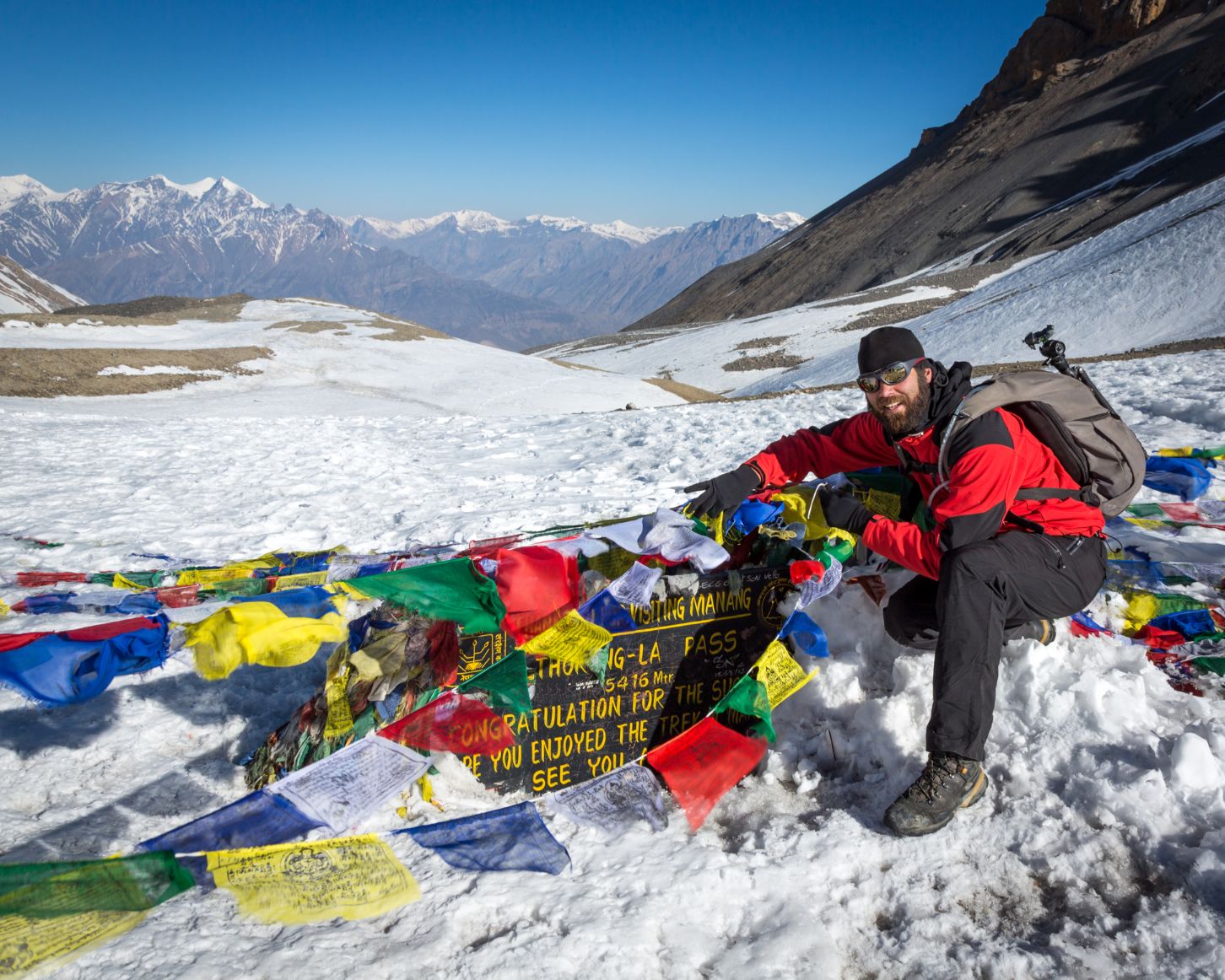 A hiker poses on the peak of Thorong La Pass, on Nepal's Annapurna circuit.