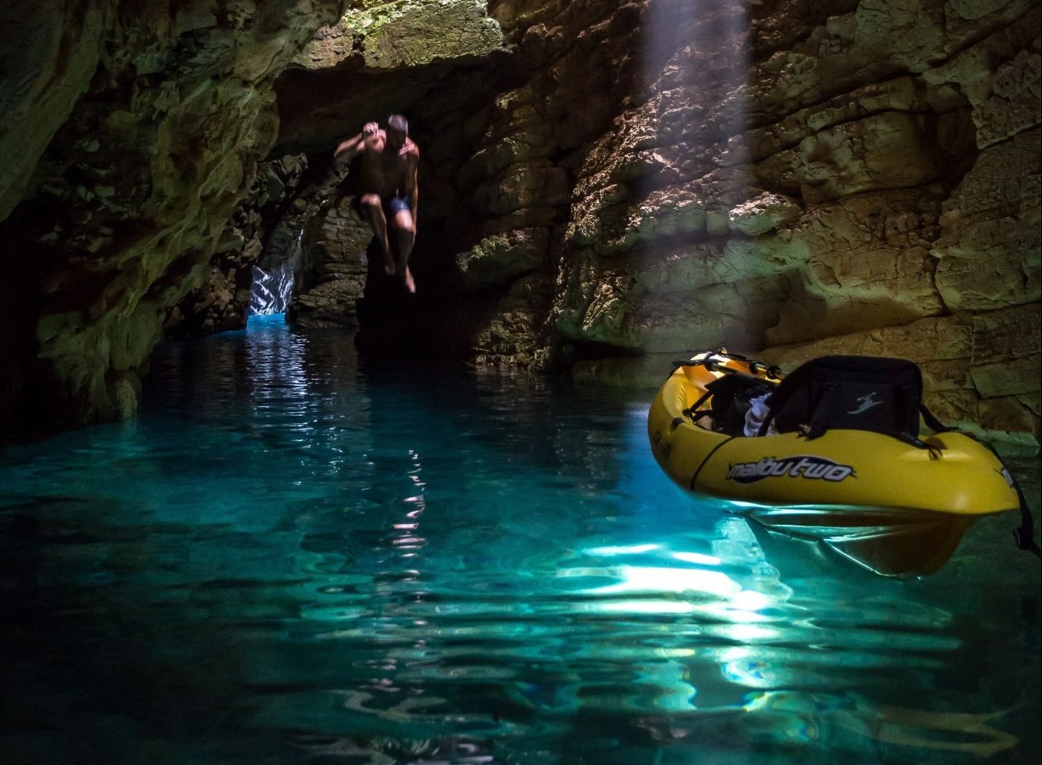 A man jumping from a kayak into the waters of a sea cave on Dugi Otok island