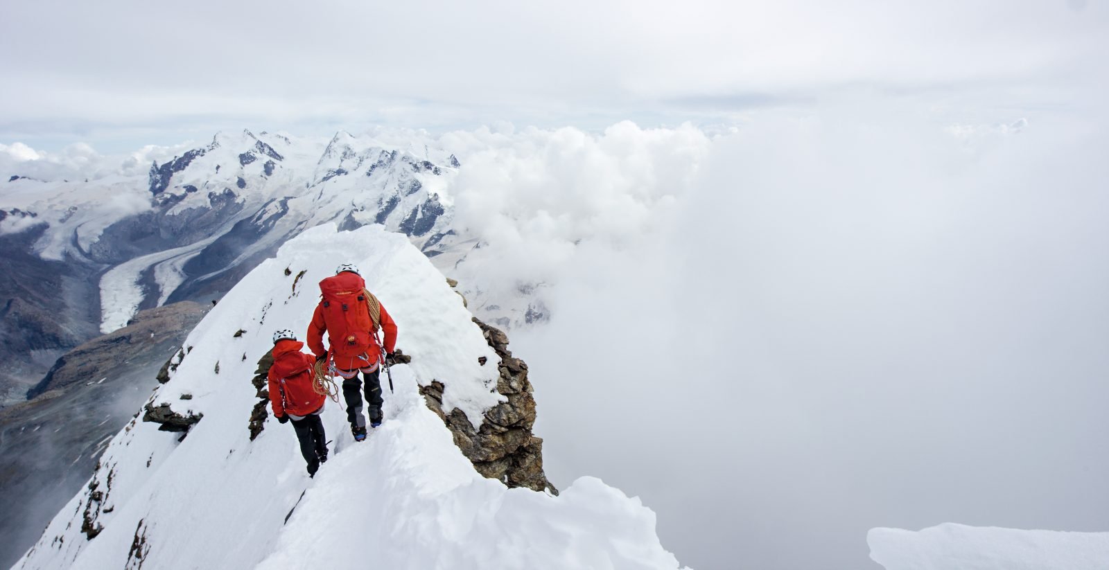Mountaineers standing above the clouds on Mont Blanc, France