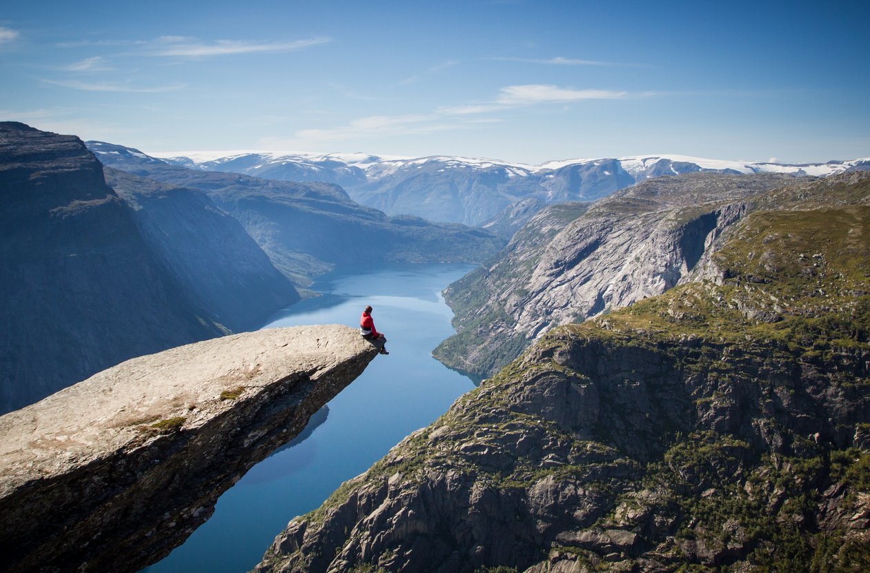 man sitting on Trolltunga rock in Norway