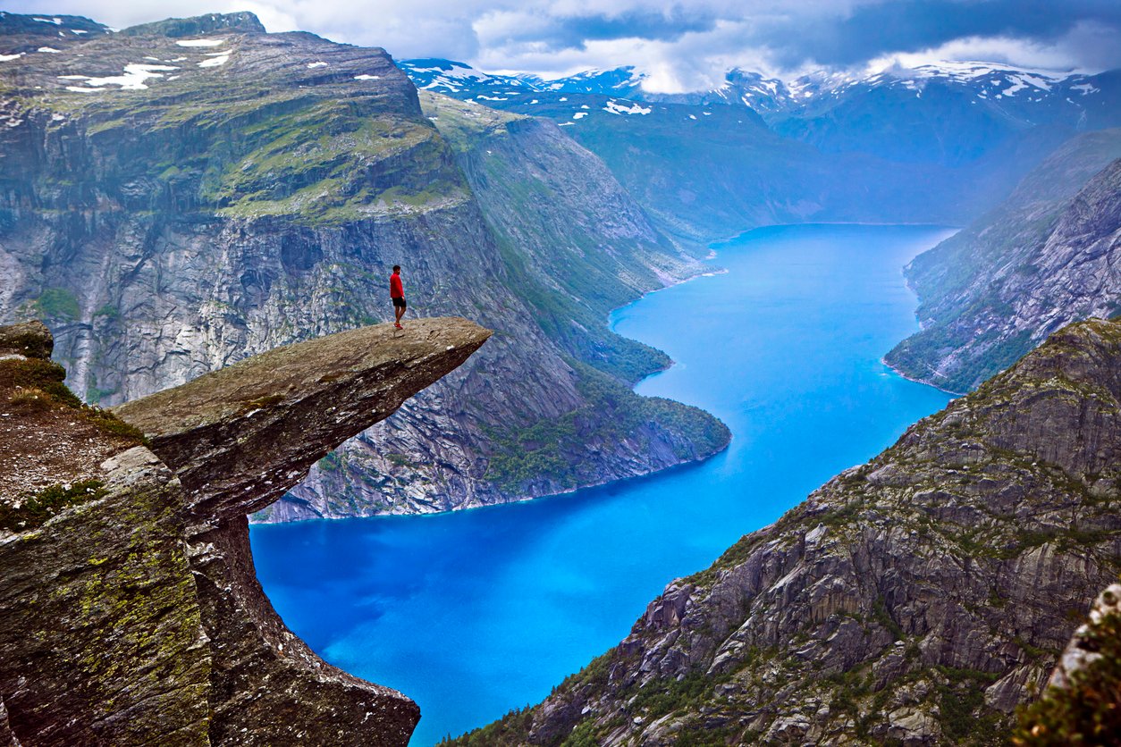 Hiker on Trolltunga rock in Norway (on the border of the Hardangervidda Plateau)