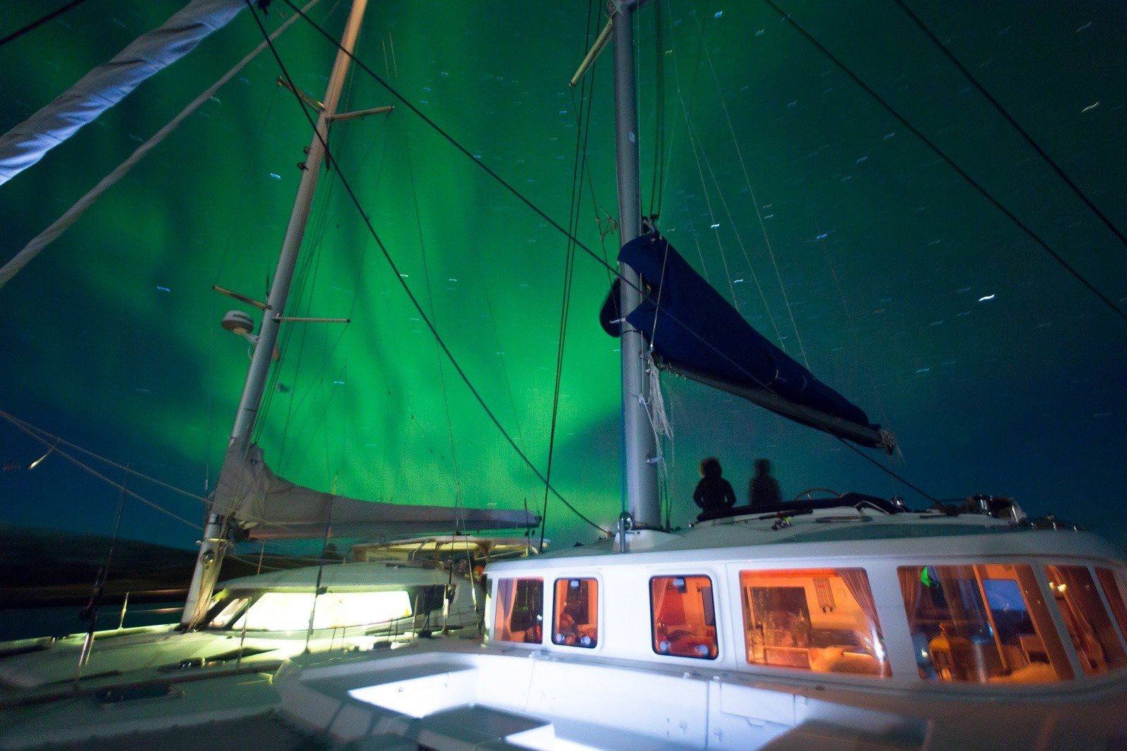 People watching the northern lights display from a boat.