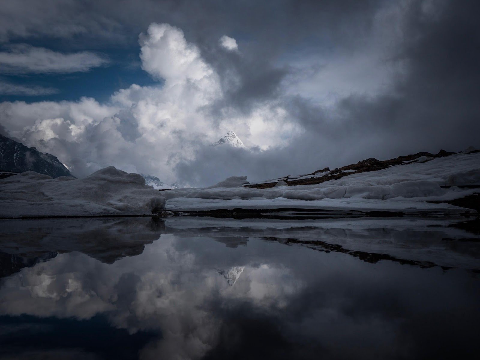 One of the Gokyo Lakes, on the trail to Everest Base Camp - Everest is in the background, shrouded by clouds.