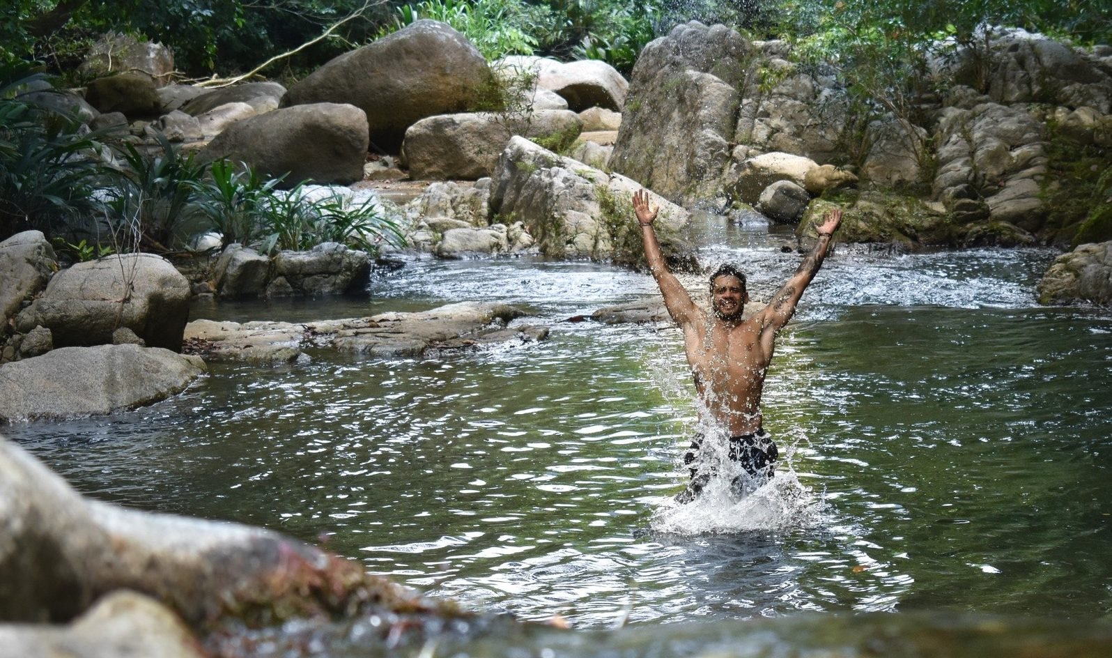 A man plunging into a quiet pool on the Ciudad Perdida trek.