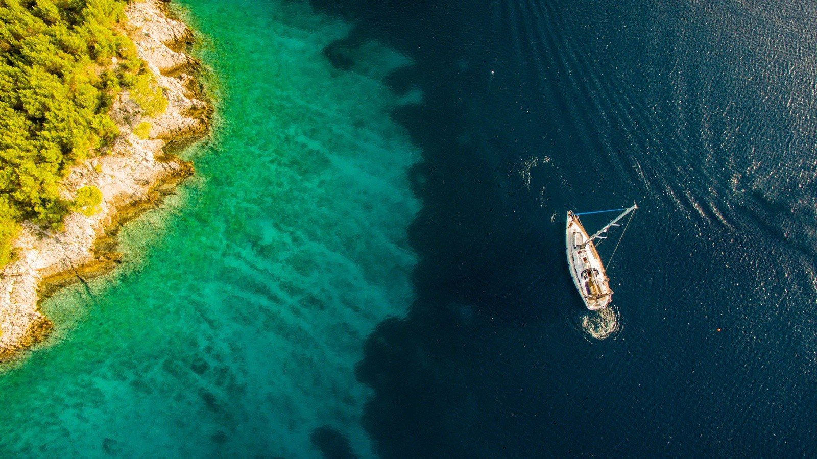 A yacht offshore of an island in Croatia, taken from above.