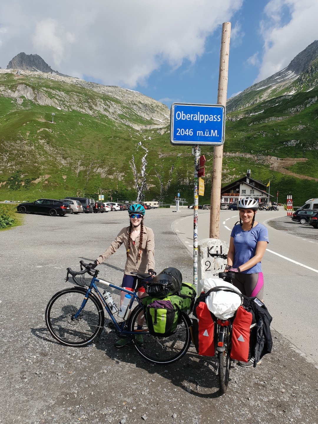 Two woman cyclists at Oberalppass, the start of the Rhine Source to Sea route.