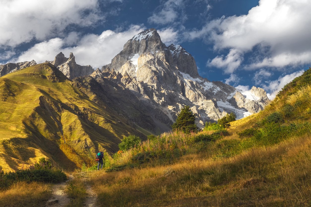 Backpacker in the Caucasus Mountains, with a view of Mount Ushba.