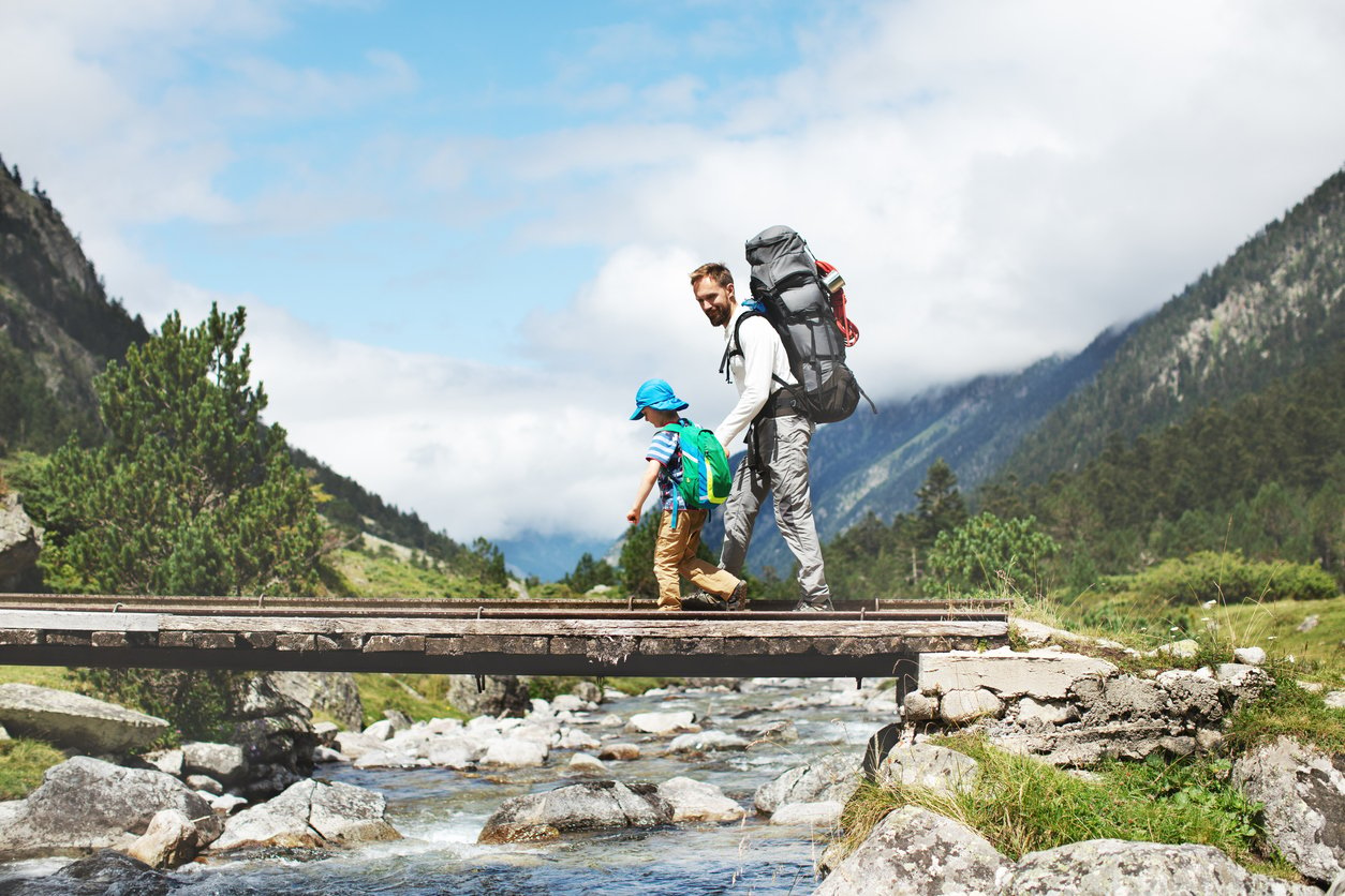 A man hiking with his young son.