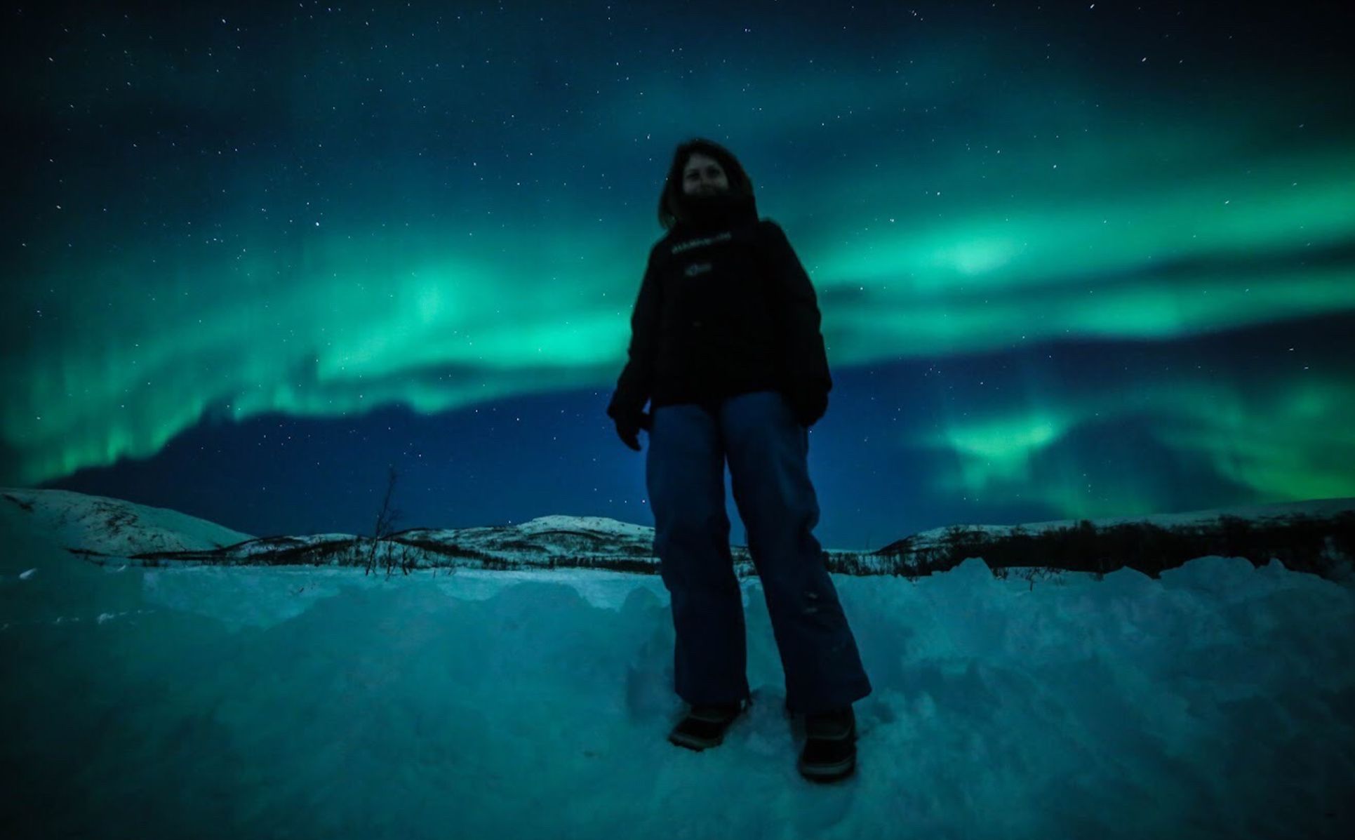 Author Tiffany Francis standing under the Northern Lights.