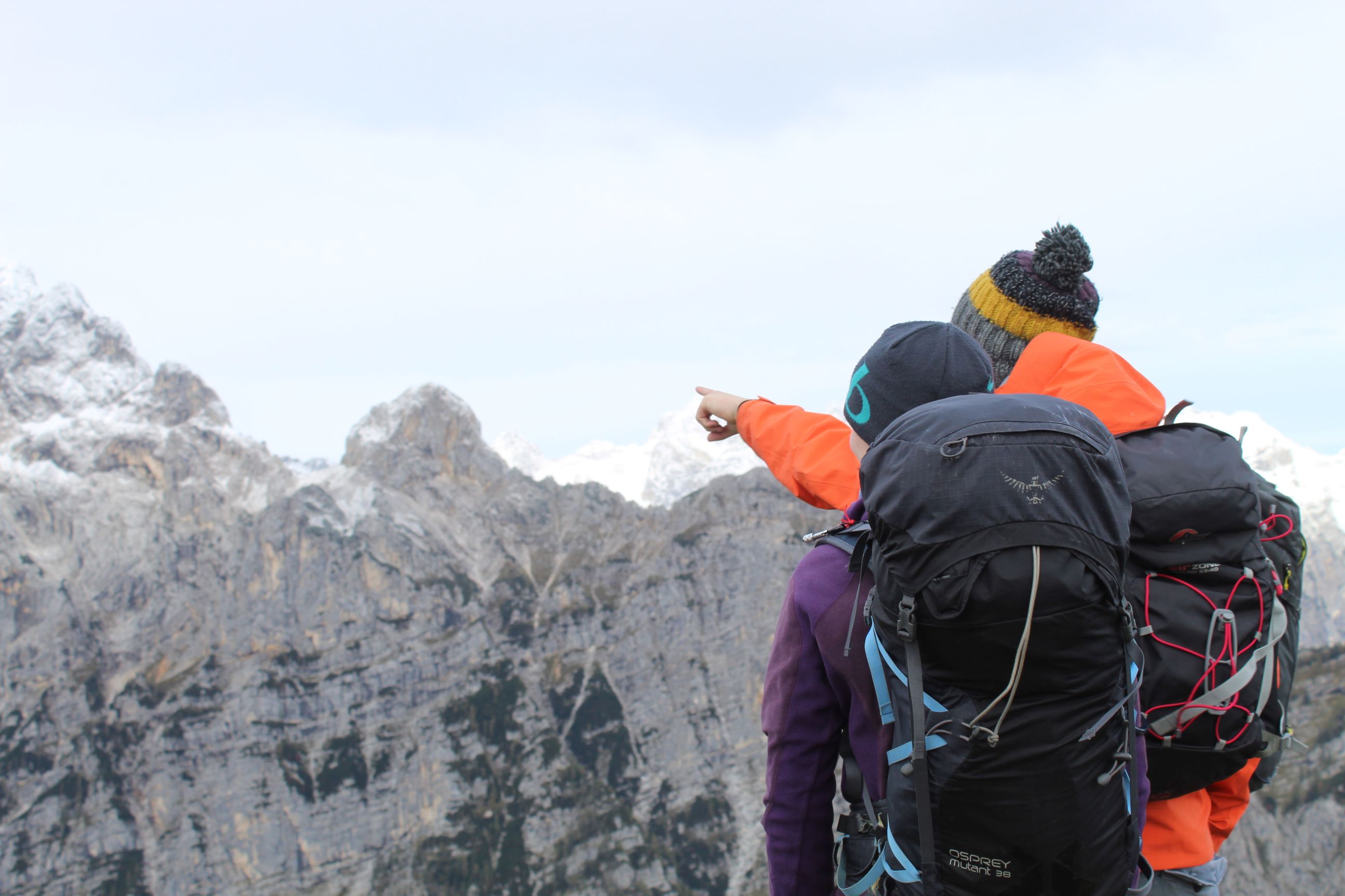 Two hikers pointing out the summit of Mount Triglav, in Slovenia.