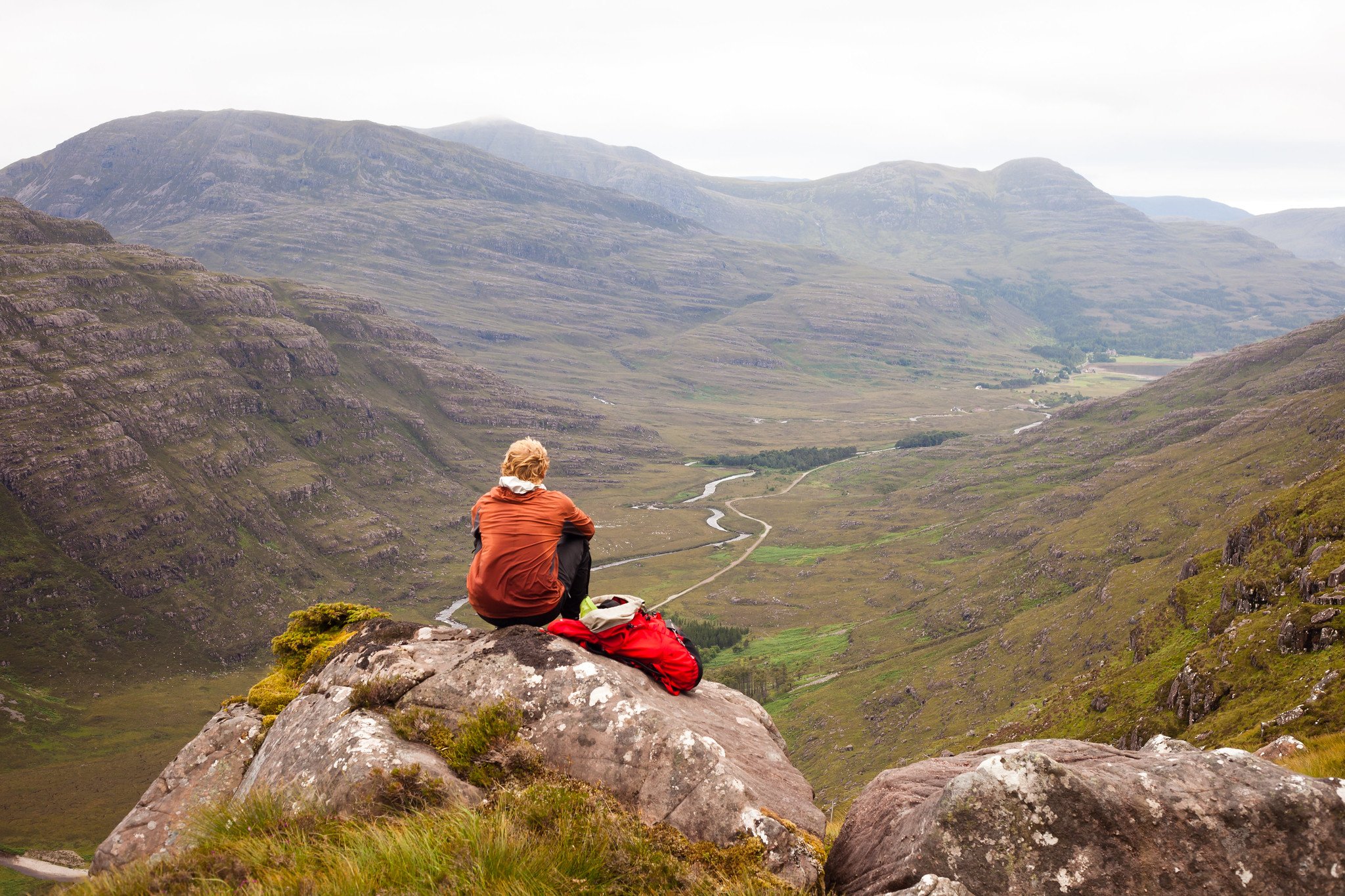 A hiker looks out at the mountain view in the Scottish Highlands.