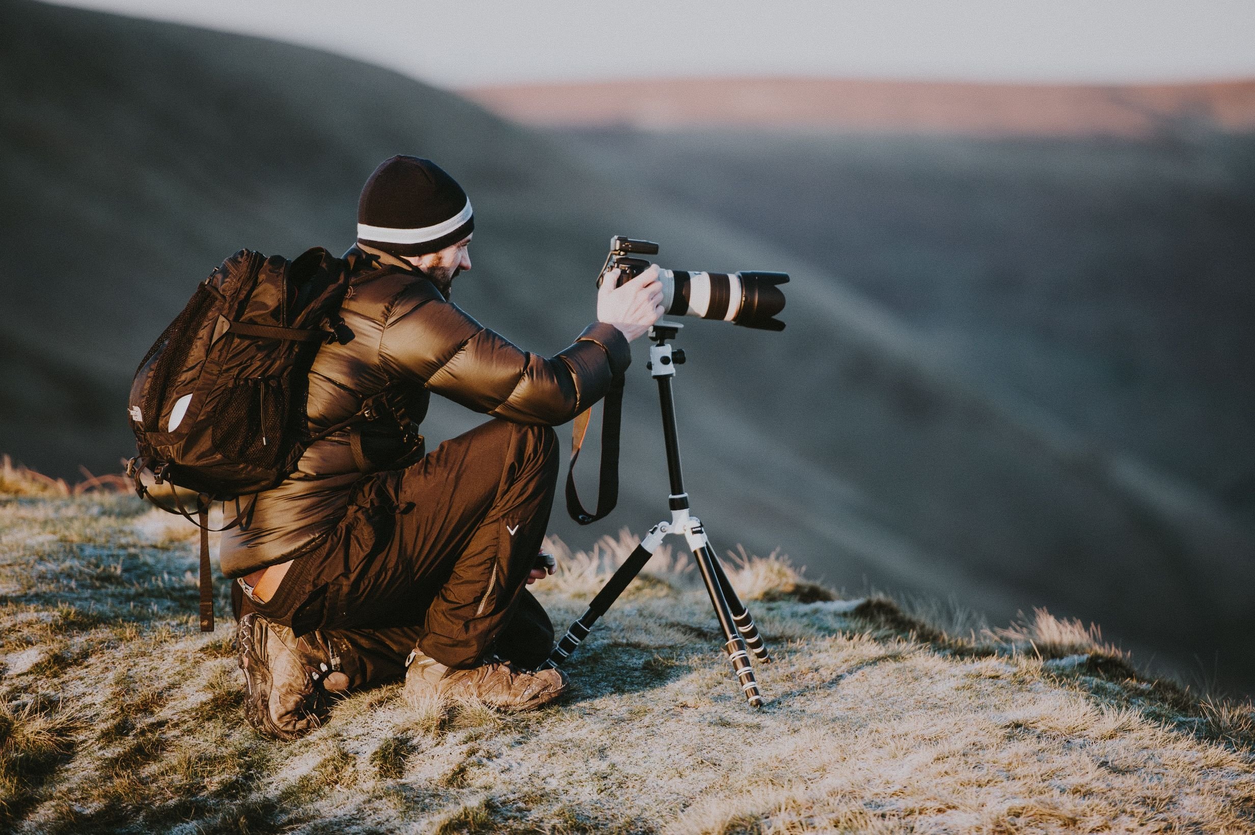 A nature photographer setting up his camera on a frosty morning.