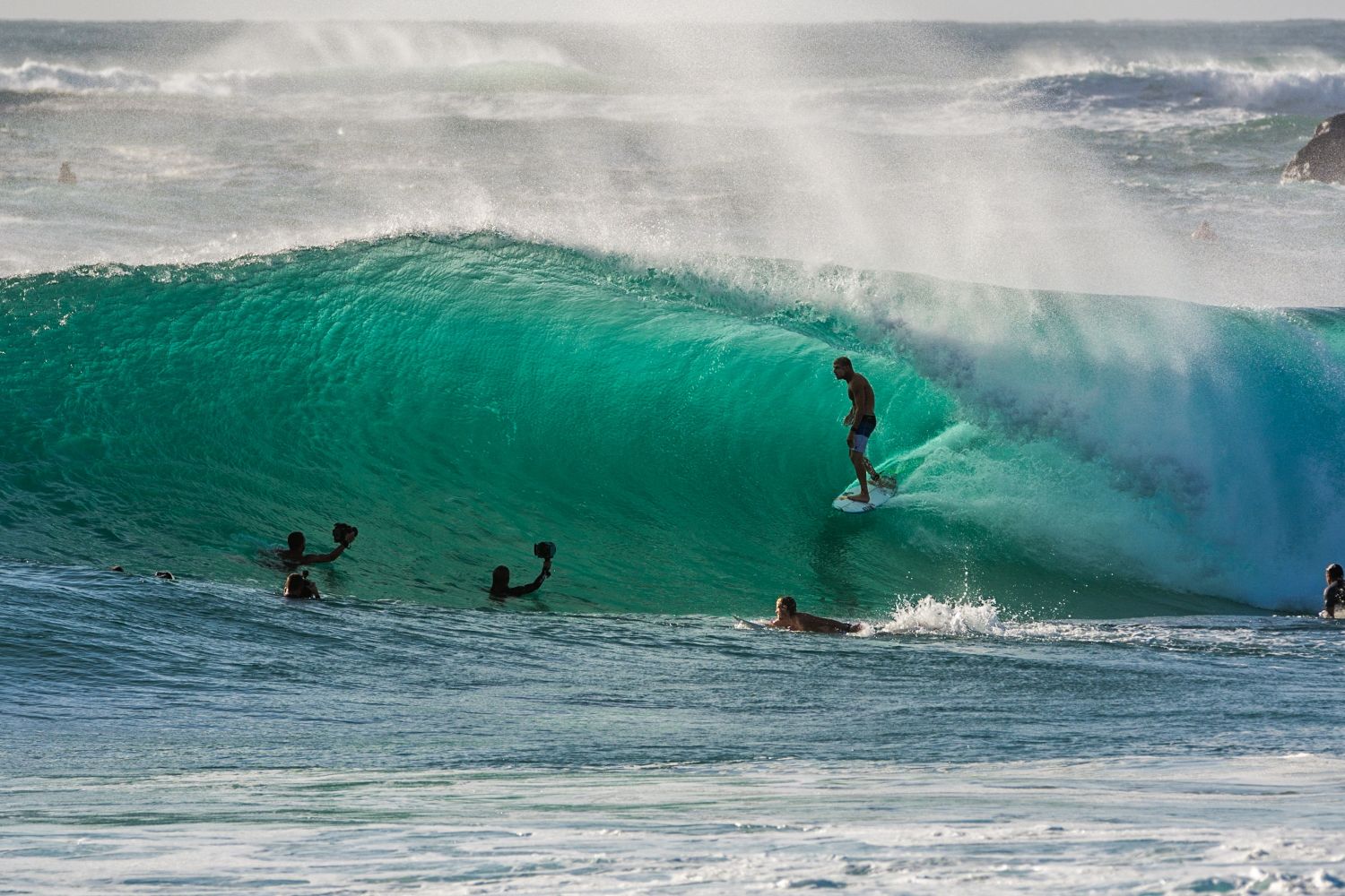 A male surfer, surfing a barrel wave.