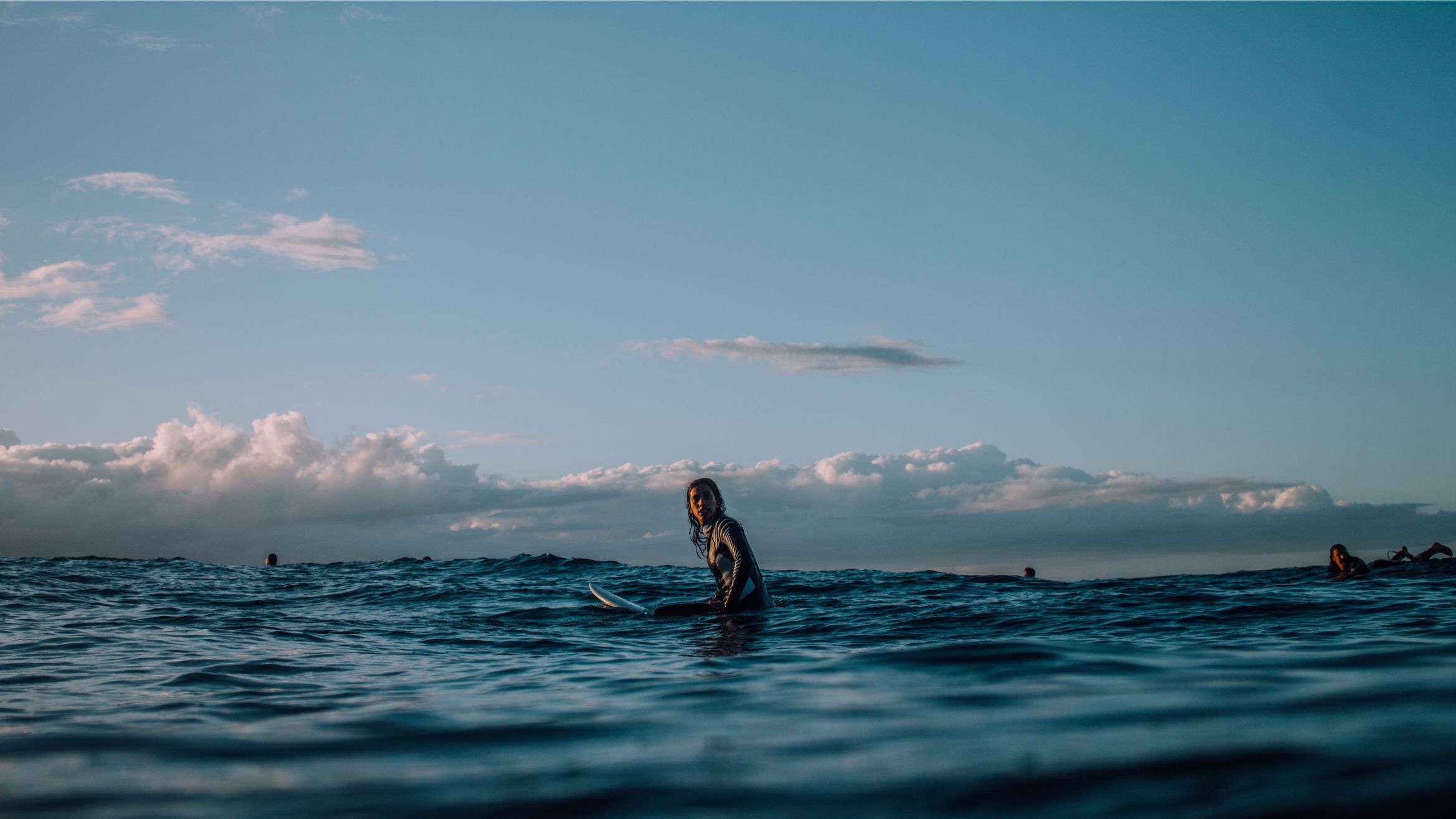 A female surfer in Piha Bay New Zealand