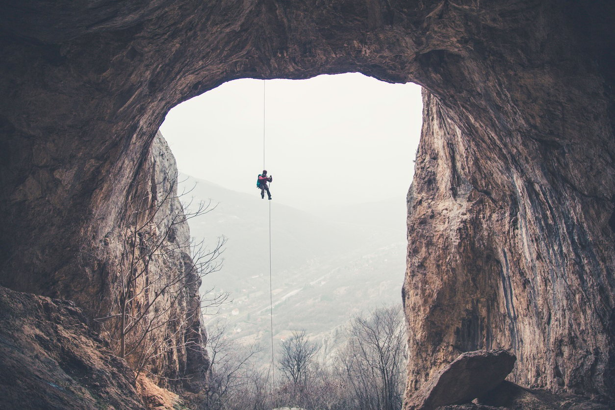 Abseiling down into a cave.
