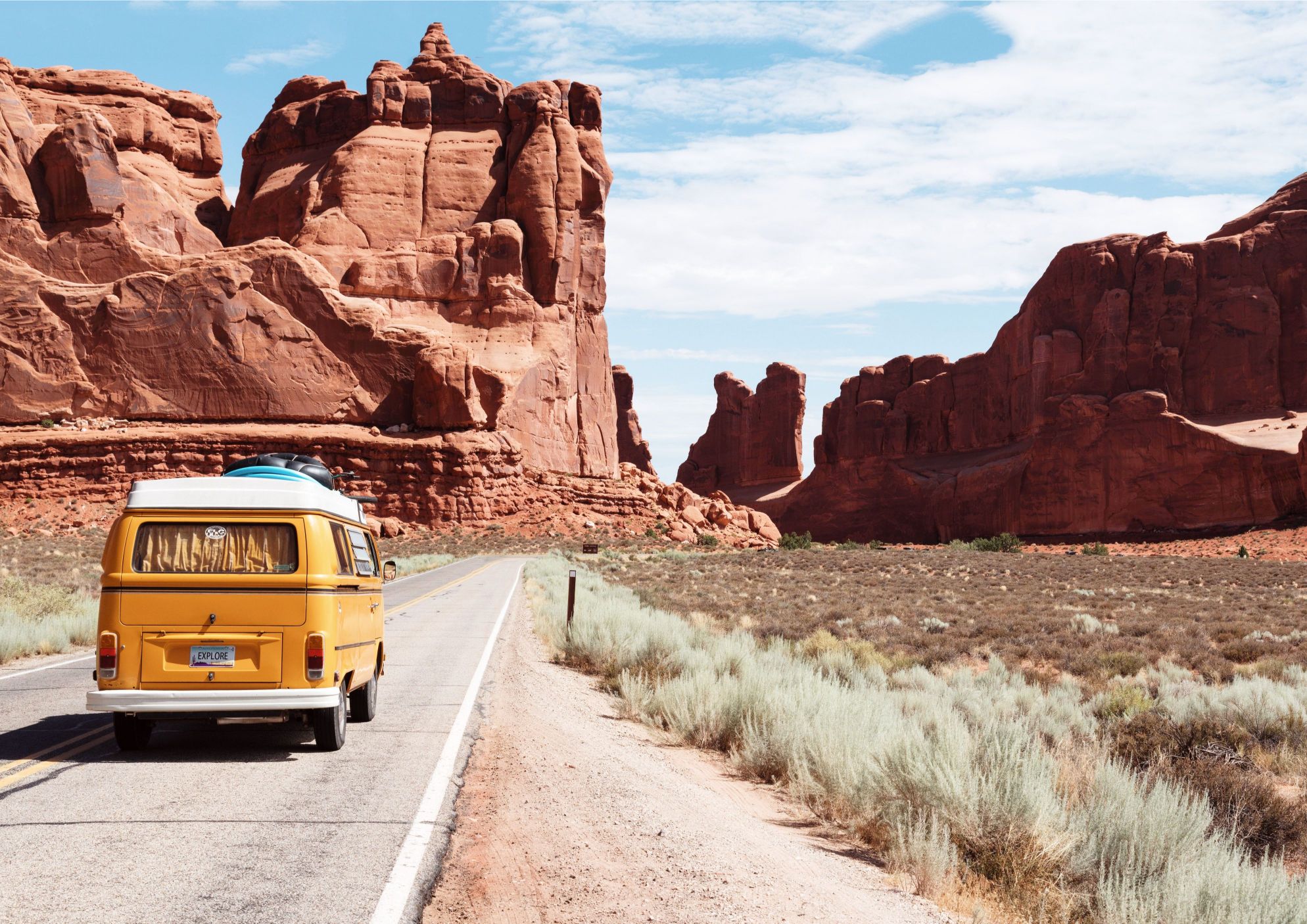 A converted van on the road in a dry and dusty American national park
