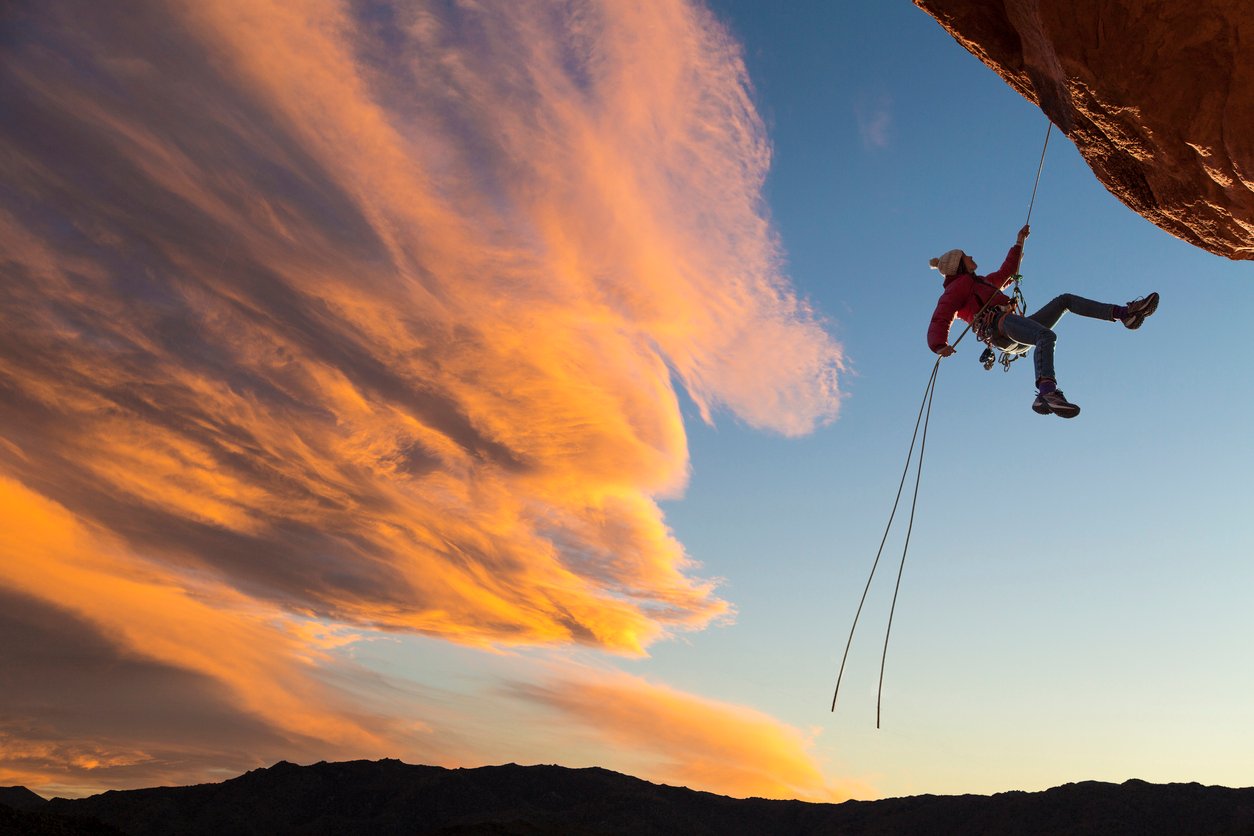 A female abseiler on an overhanging cliff.