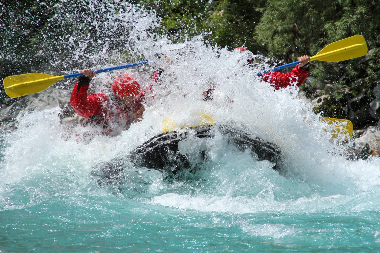 A raft splashing into a white water rapid.