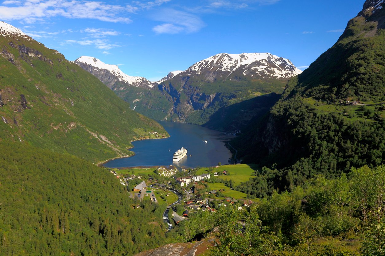 View of Geiranger with a boat in the fjord beyond.