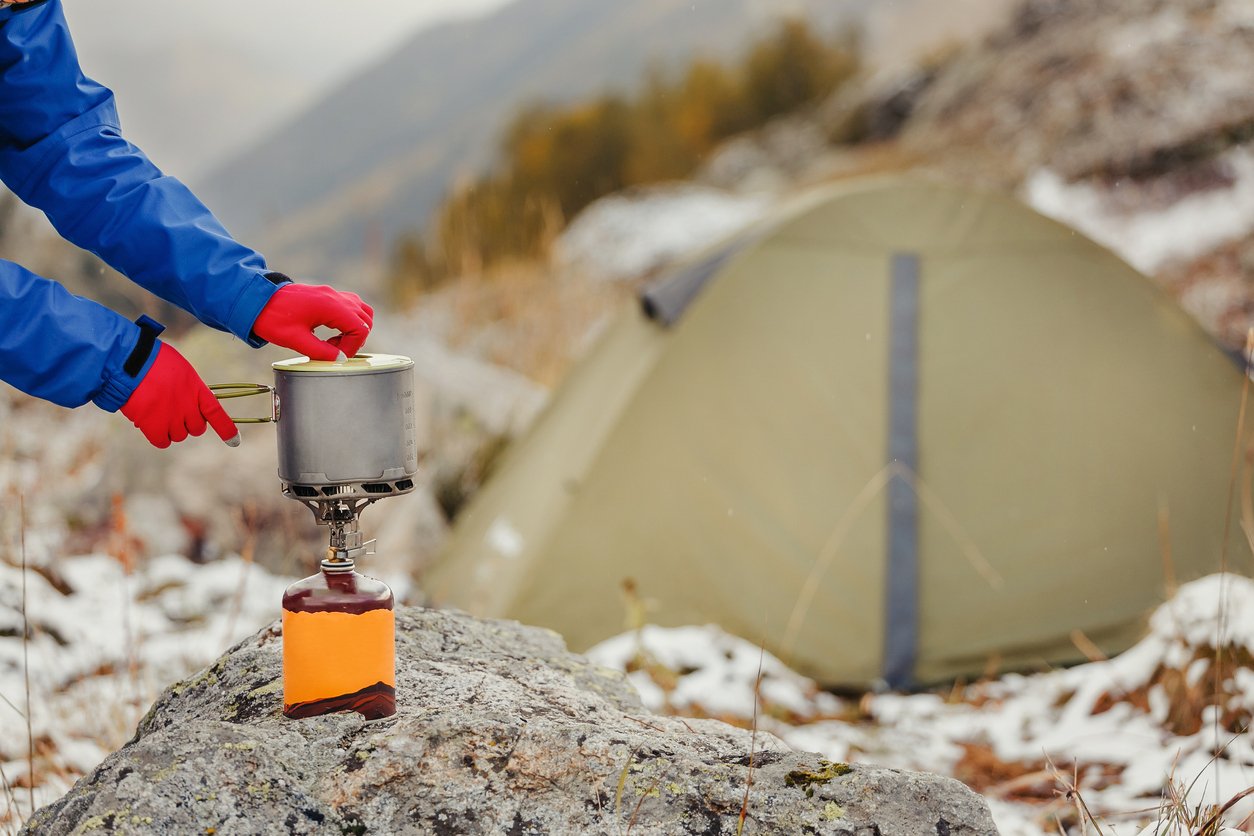 Someone cooking on a camping stove.