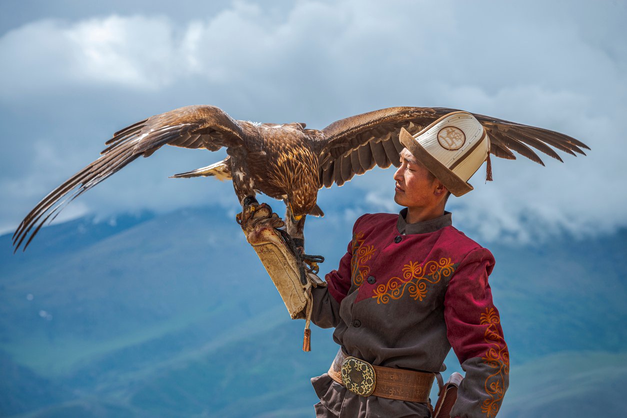 A traditional Kyrgyz Hunter holding his hunting eagle