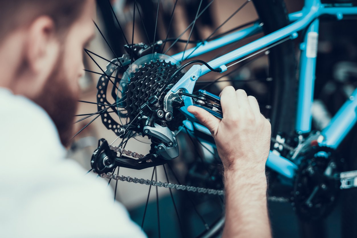 A bike mechanic toys with the cassette of a mountain bike.