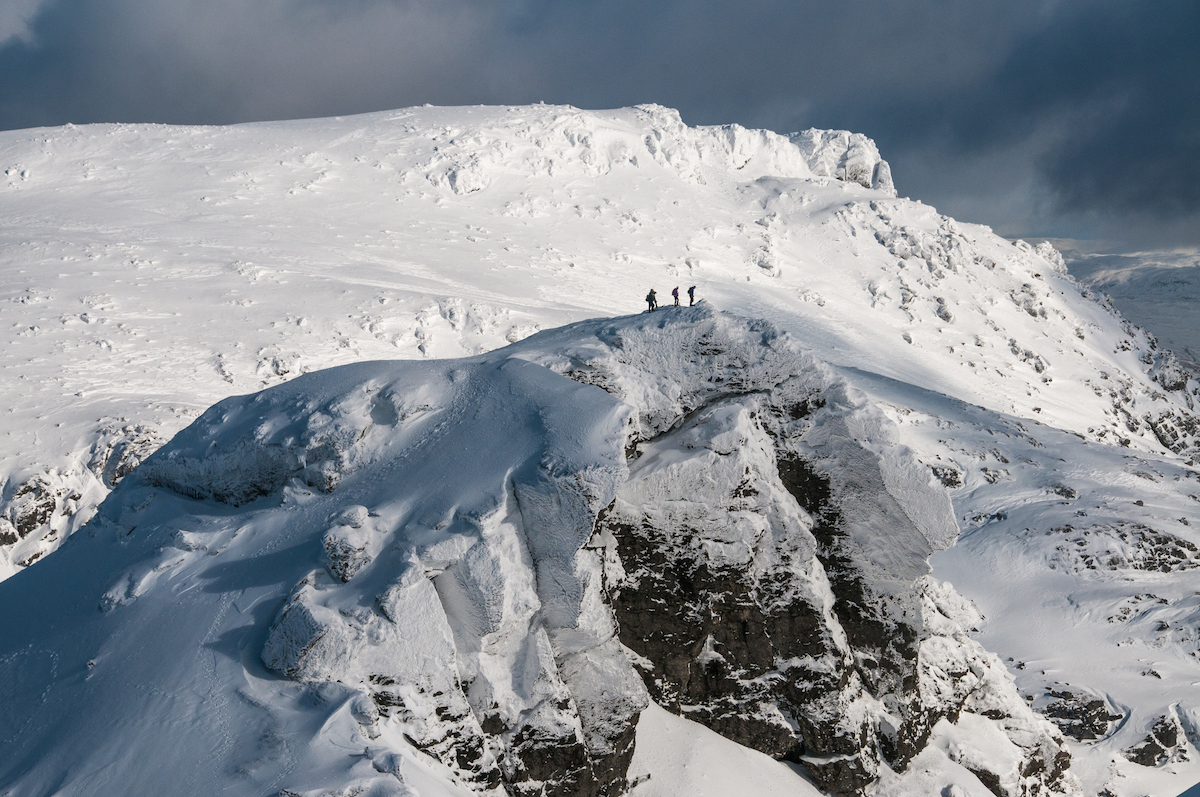 A group of walkers on top of The Cobbler in Scotland in winter