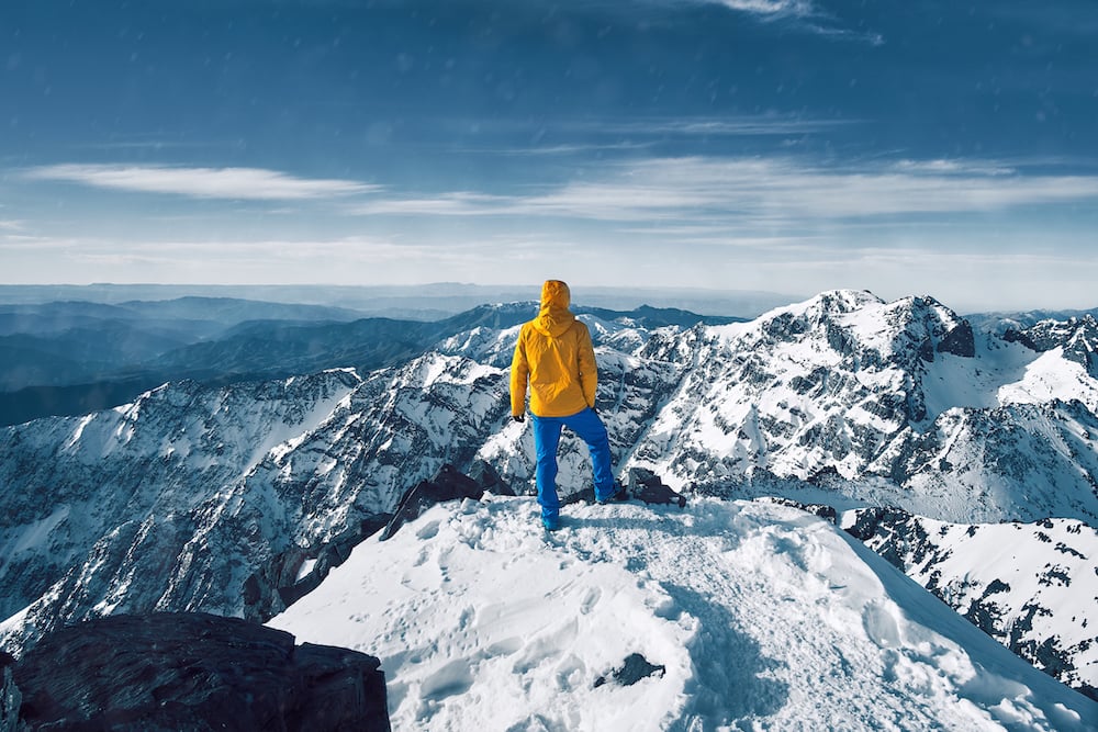 Standing at snow covered top of the peak of Jebel Toubkal in Atlas mountains Morocco