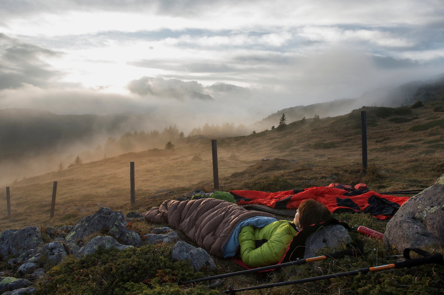 A woman using a rock as a pillow, looking out on the great outdoors.