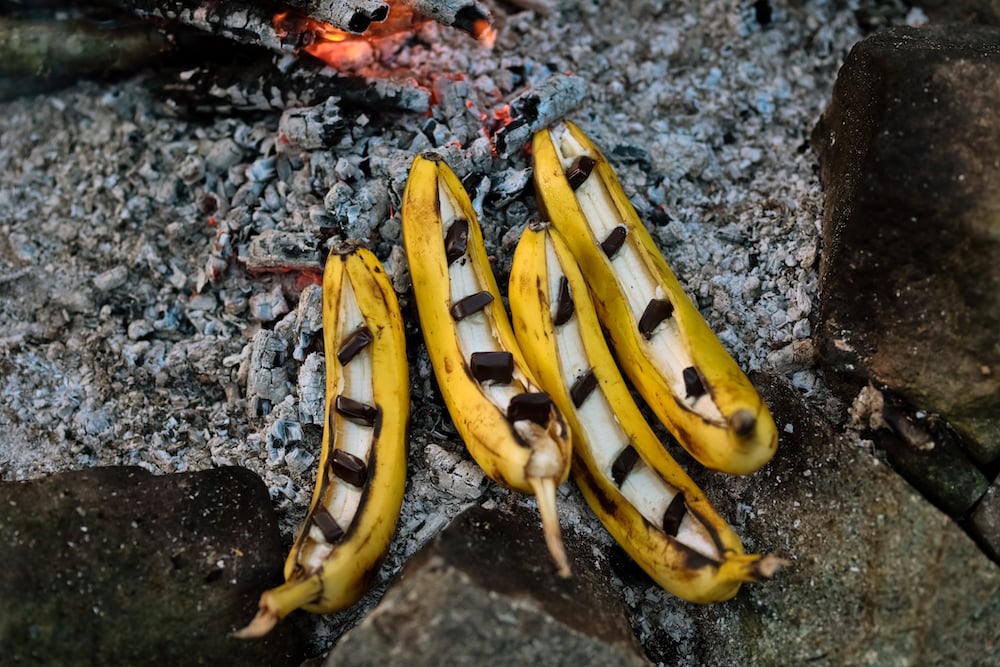 Bananas with chocolate squares on, ready to go on the campfire.