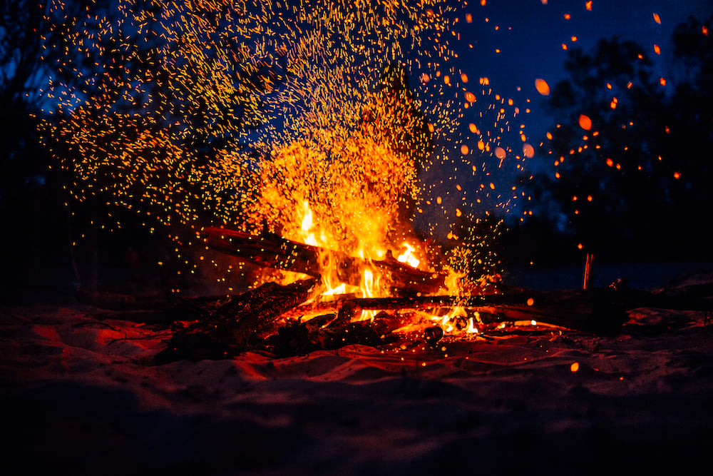 A blazing campfire at night. 