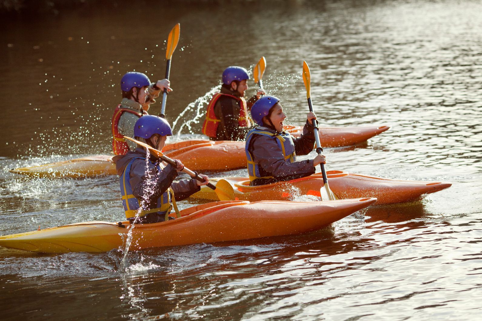 Four kayakers on a river in the UK, one of the best places for canoeing and kayaking in Europe.