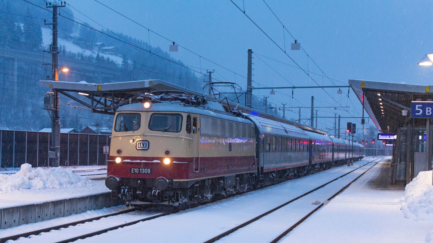 The Alpen Express train rolling into a stop in the morning snow of Austria
