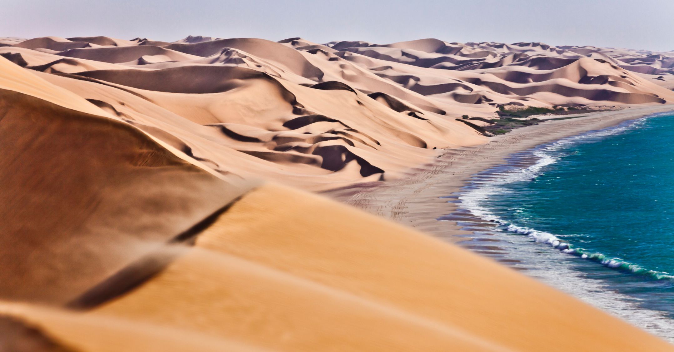 The sand dunes of the Namib Desert meeting the waves of the Atlantic in Namibia