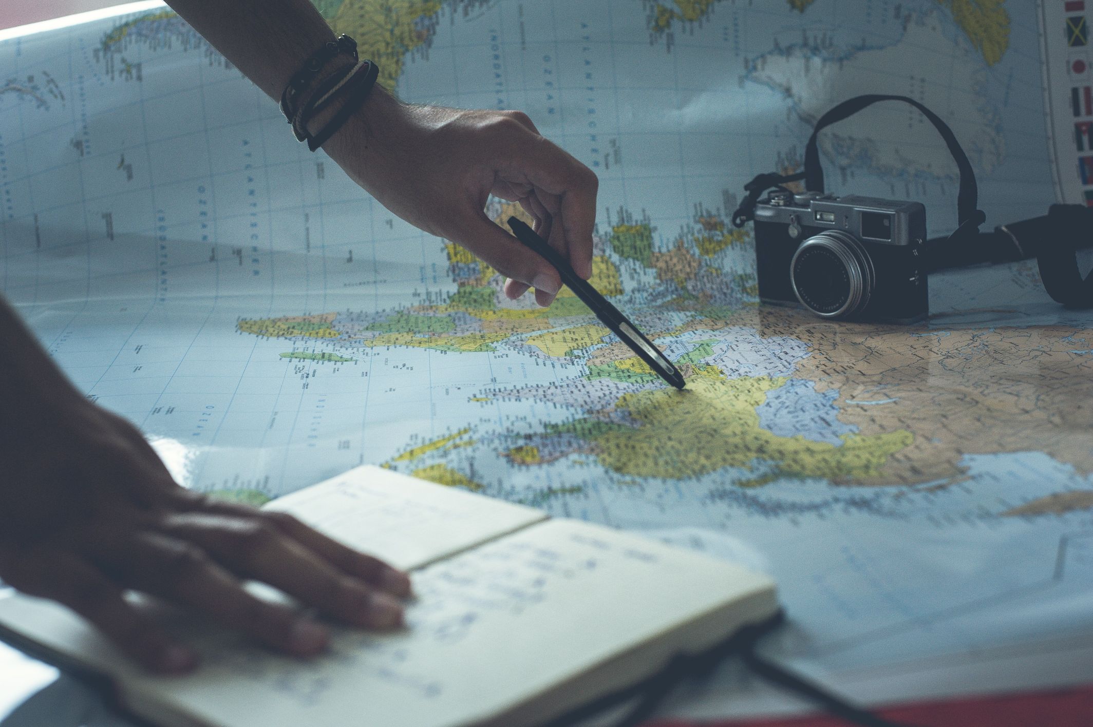 Planning an adventure with a map, notebook and camera.