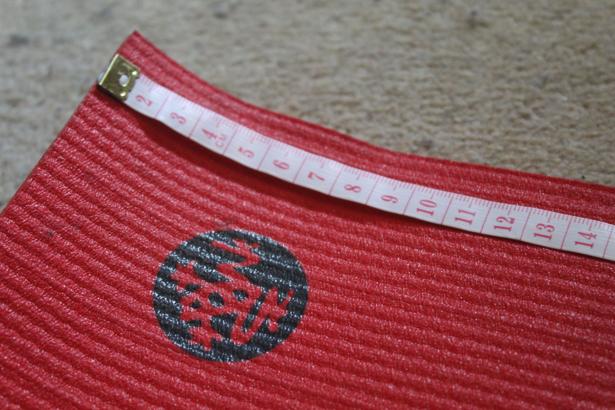 The top of a yoga mat with a measuring tape across it.