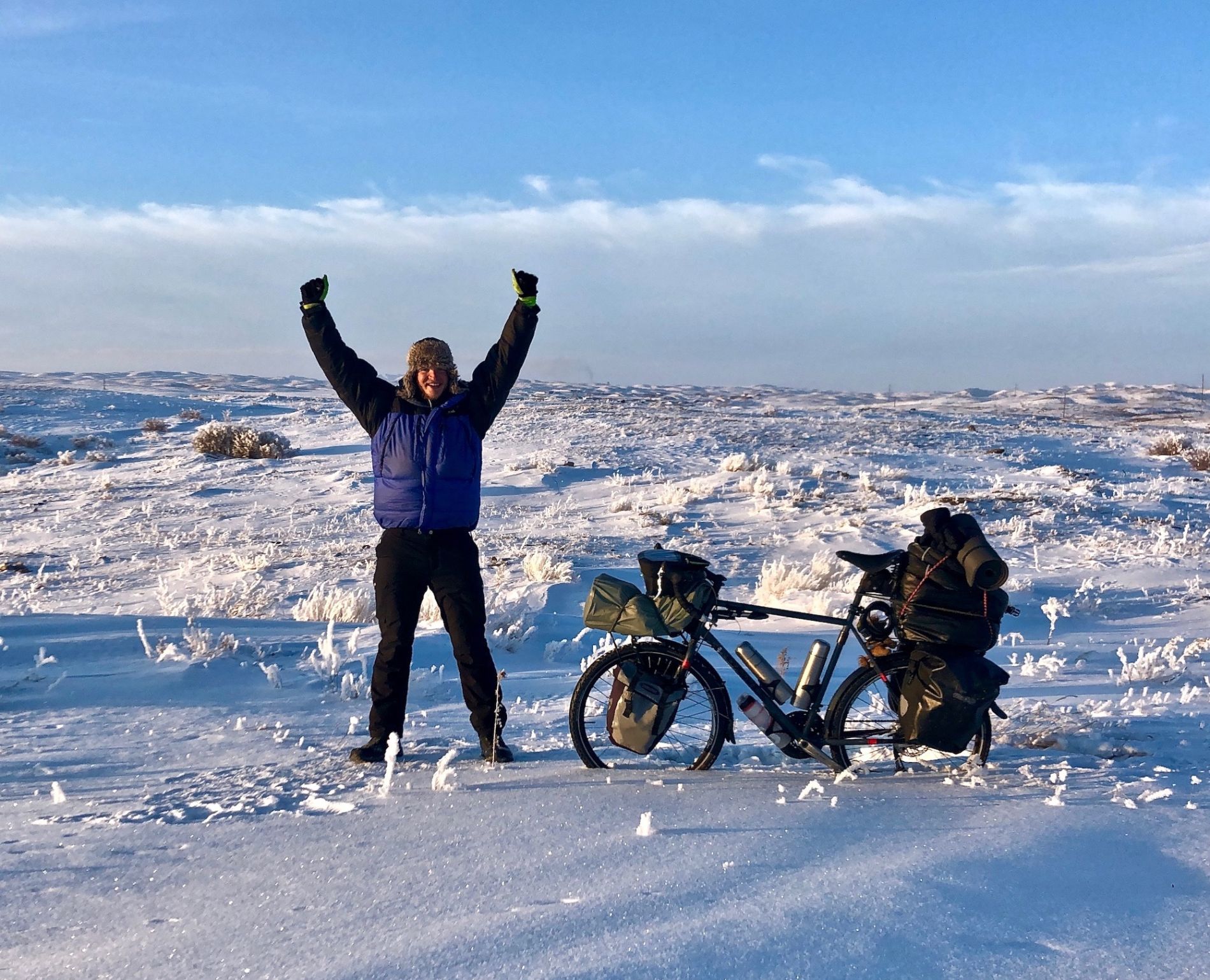 Geordie Stewart posing with his bike in the snowy landscape of Kazakhstan in winter