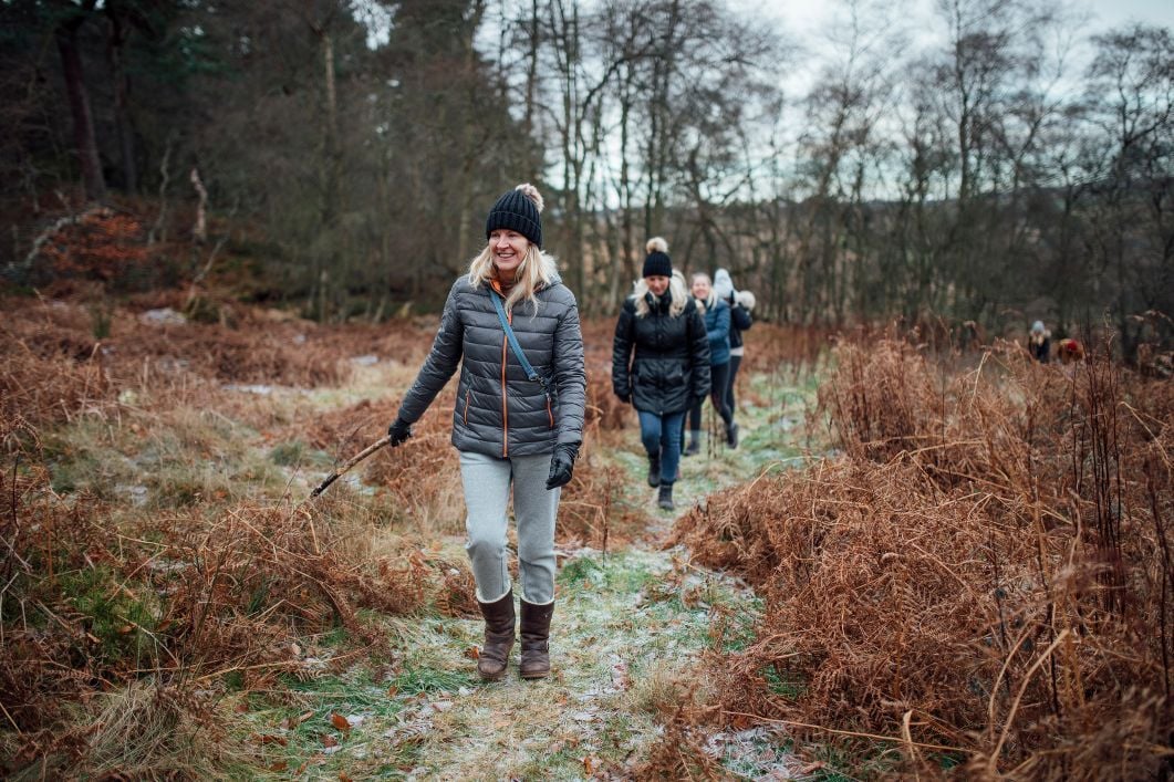 A group of women walking in a forest on an autumn day.