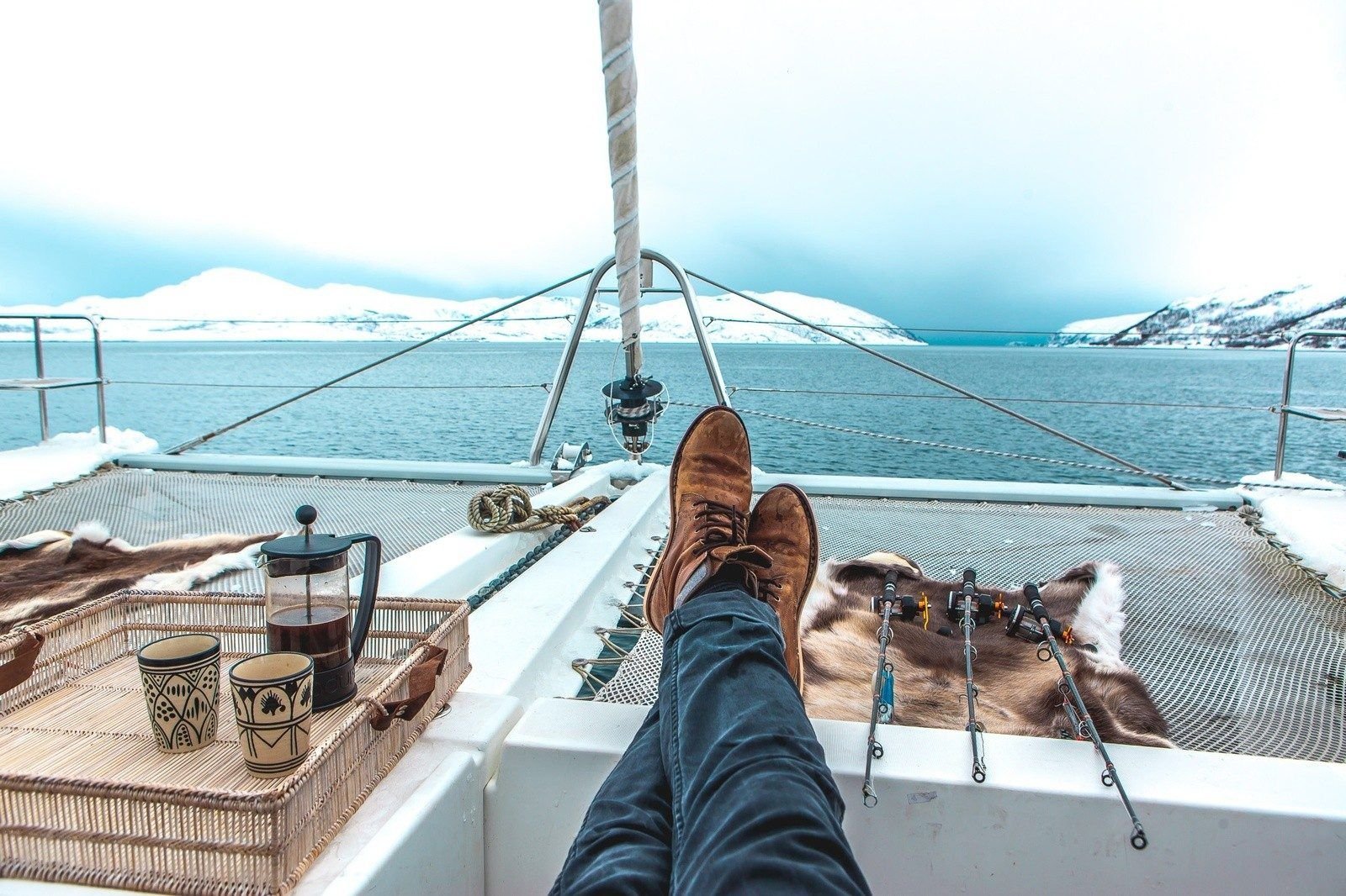 The outstretched legs of someone relaxing on the deck of a boat travelling through the Arctic.