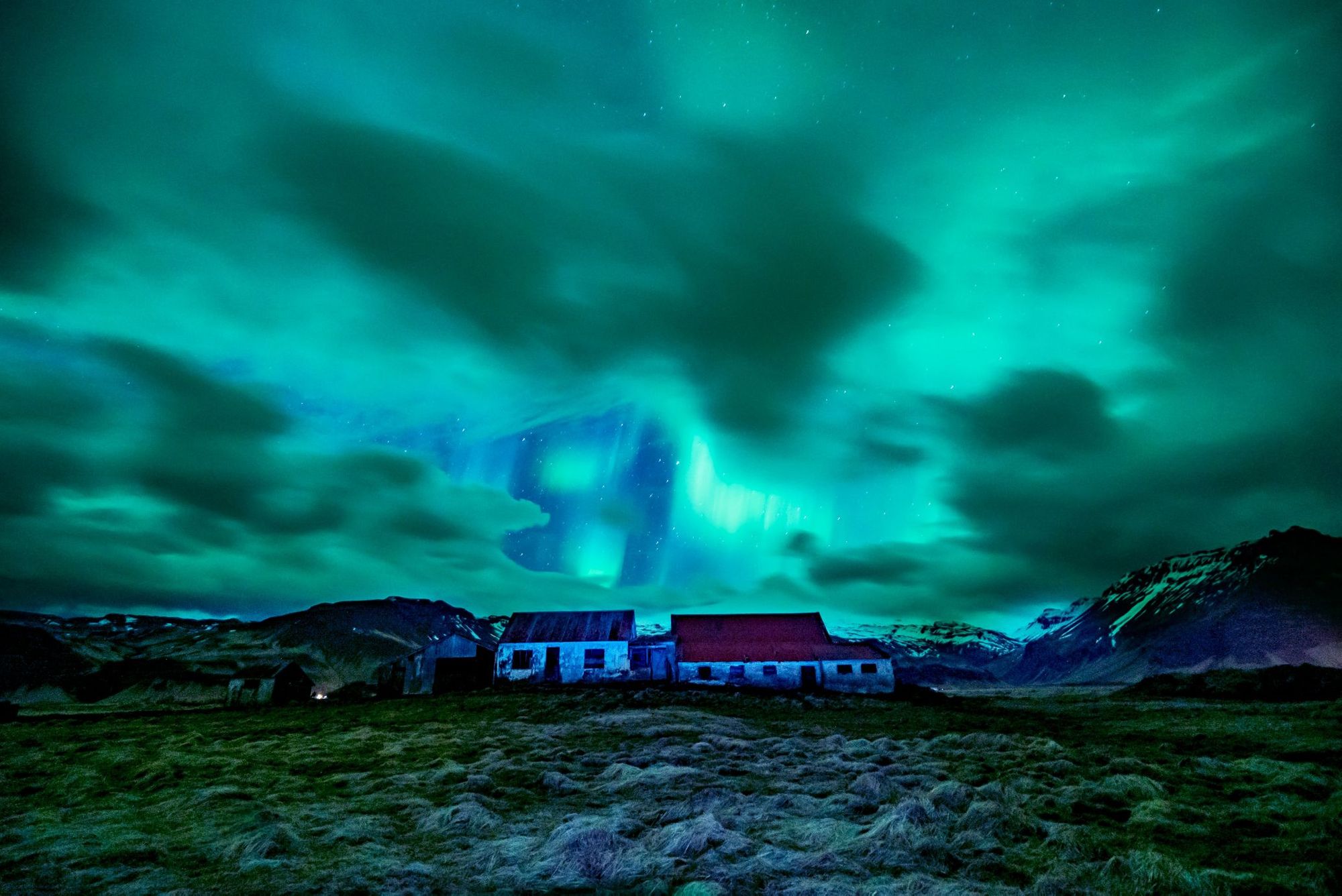 Northern lights shining over a farm in Iceland.