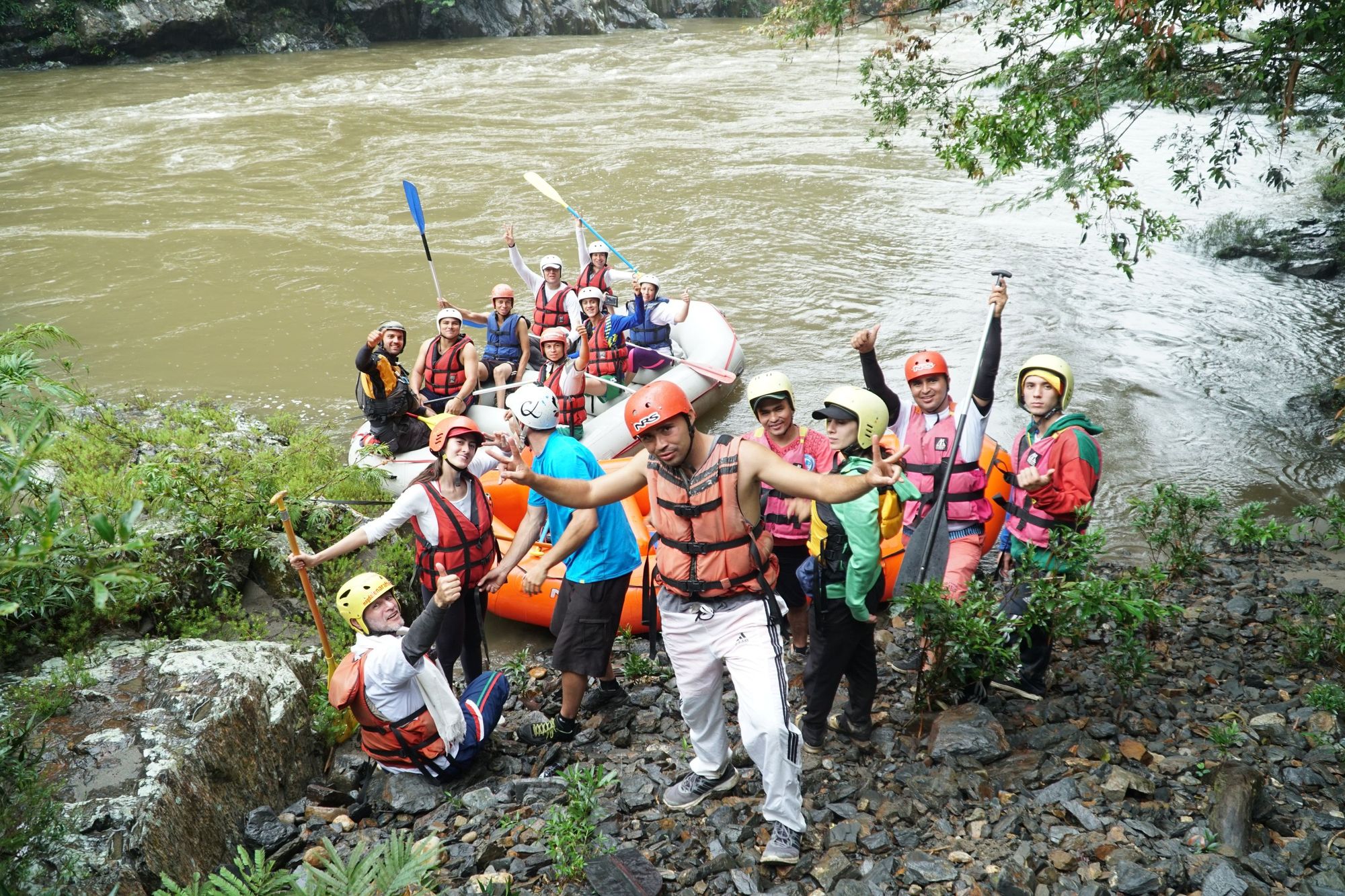 A rafting group posing on the banks of the Samana River, in Colombia