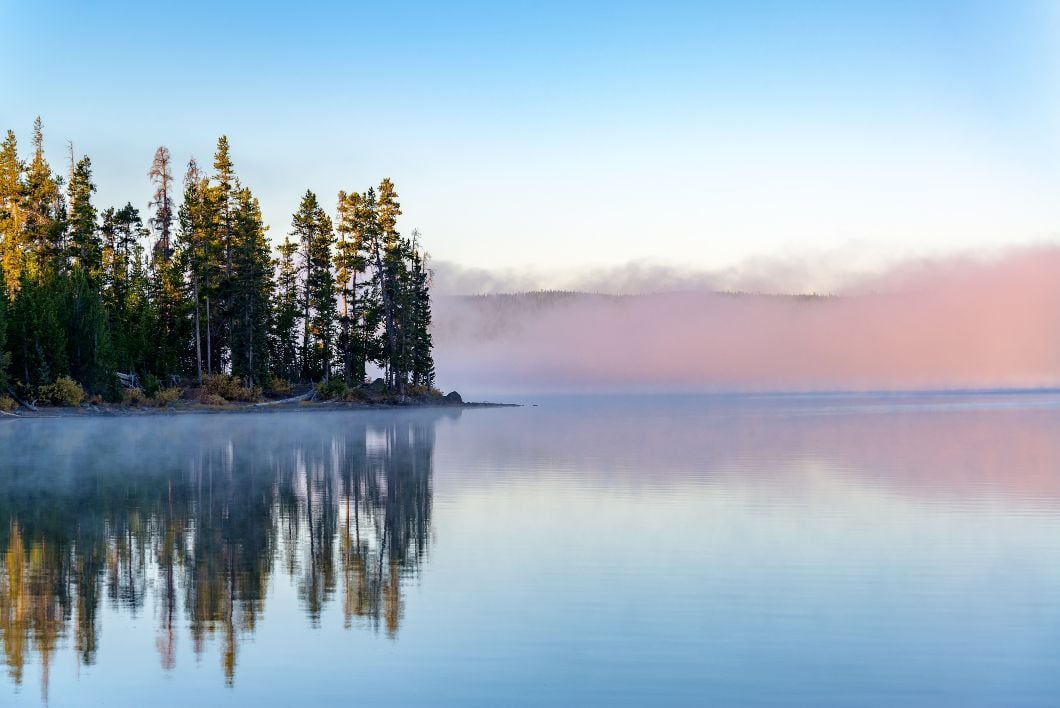 Early morning fog rolls over Lewis Lake in Yellowstone National Park in Wyoming.