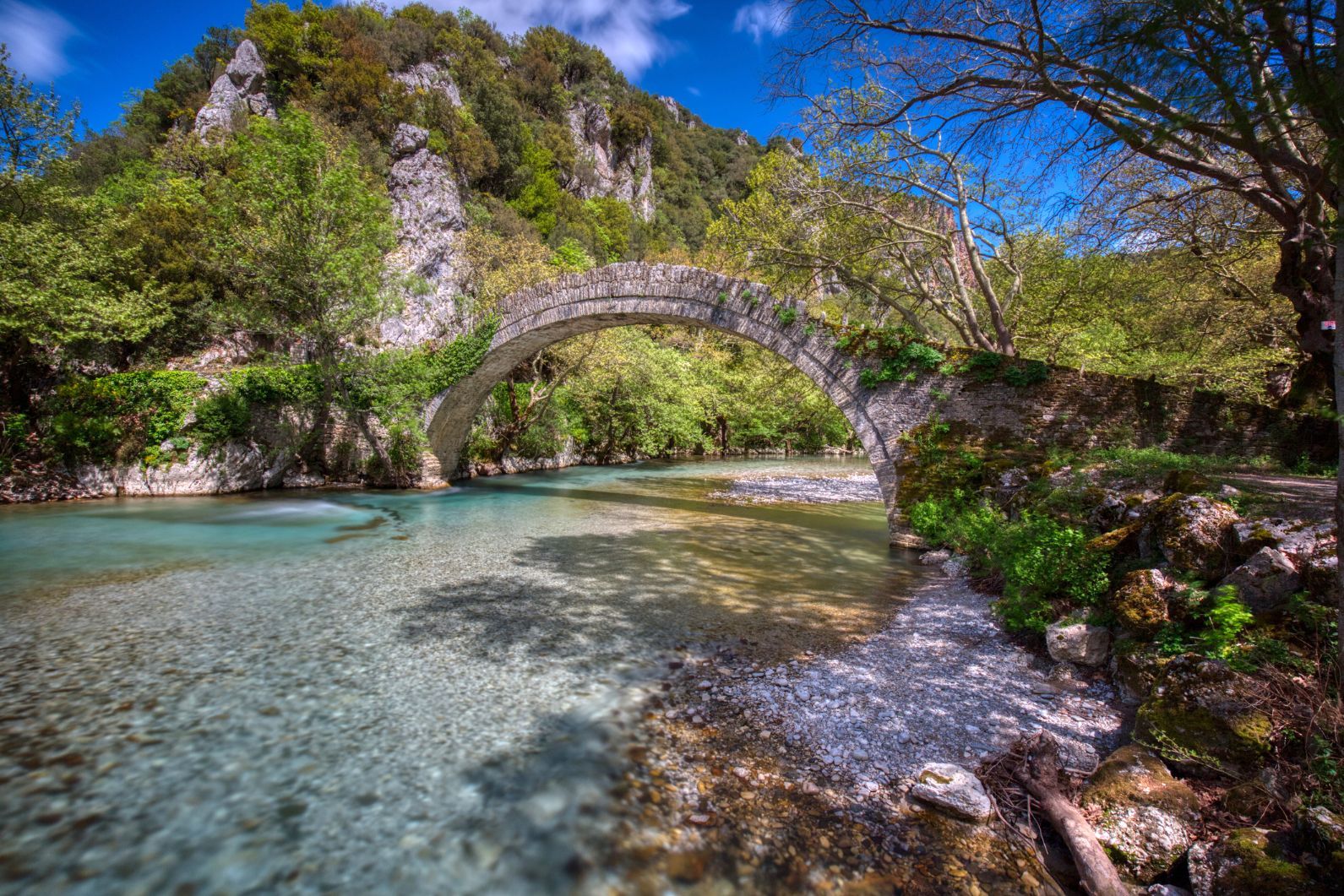 The Aoös River, in Greece, flowing under a small stone bridge.
